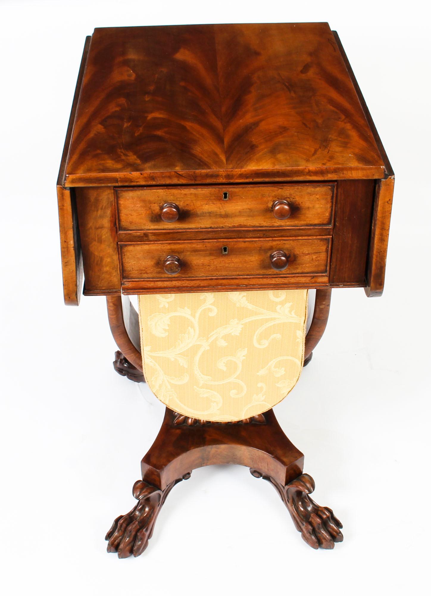 An exquisite antique William IV flame mahogany drop leaf work table, circa 1830 in date.

The drop-leaf top with rounded corners supported by fly brackets ornamented with foliate scroll carving, above two cock-beaded drawers to one side and
