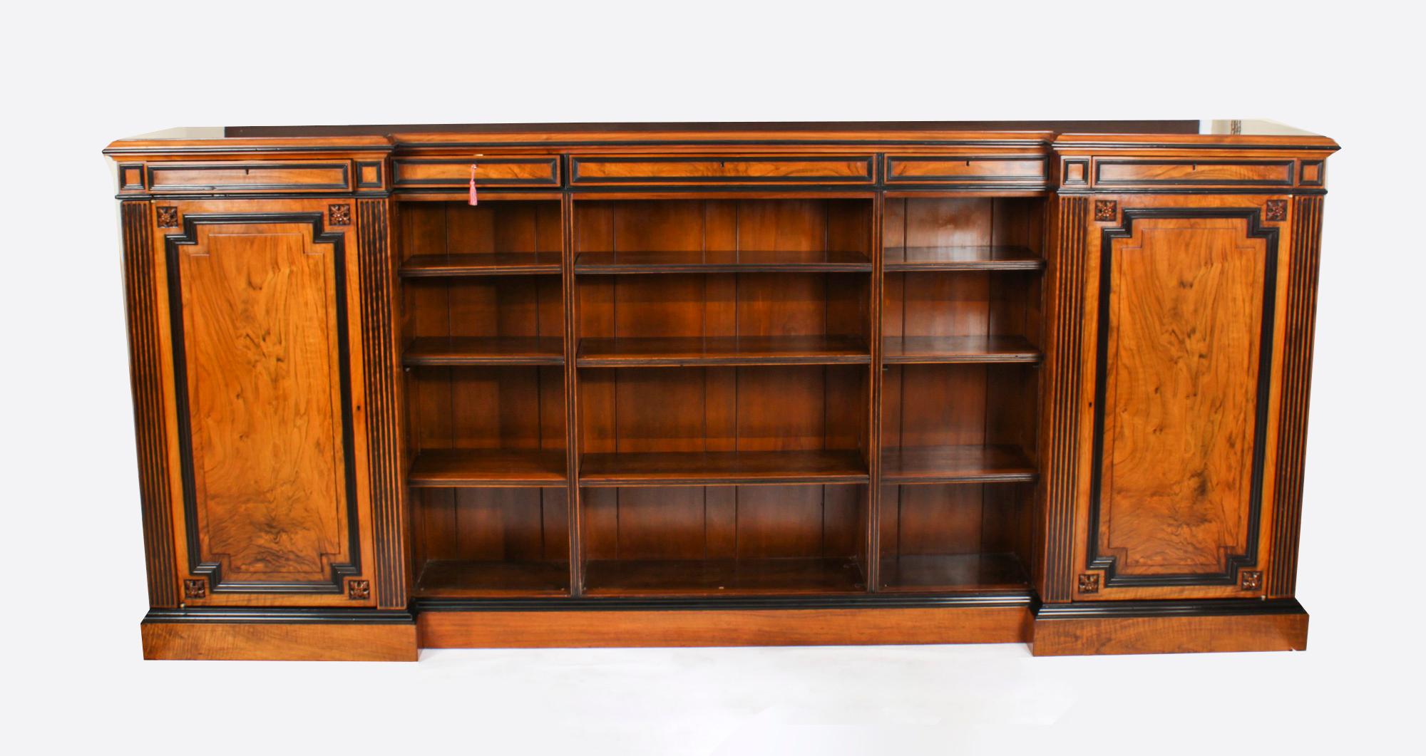 This is a beautiful antique William IV figured walnut and ebonised low breakfront bookcase, circa 1835 in date.
 
It has a shaped top with five frieze drawers above a central open bookcase with three adjustable shelves all between fluted columns.