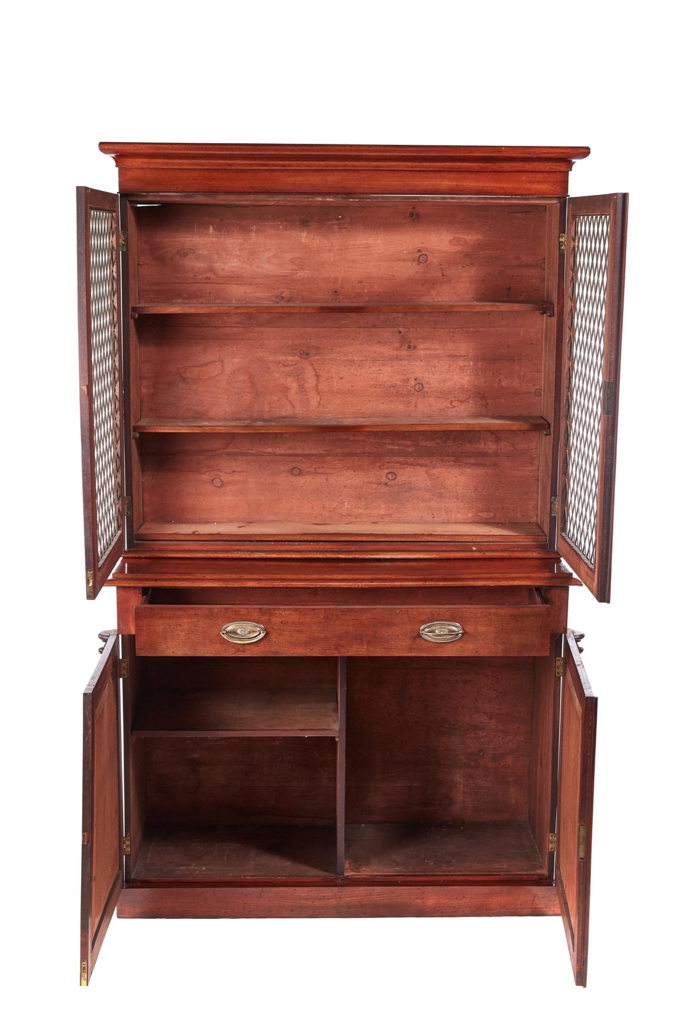 Quality antique William IV mahogany bookcase. The upper section having a shaped cornice over a pair of mahogany doors with brass grilles opening to reveal an interior with three adjustable shelves The base having one long drawer with brass handles