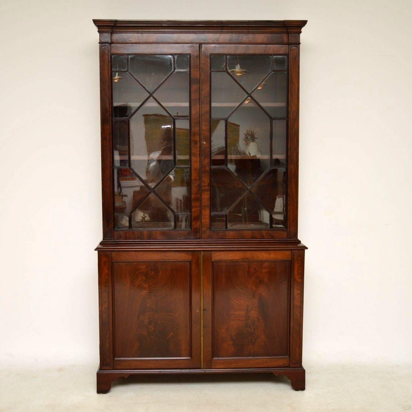 This antique William IV mahogany two section library bookcase dates from circa 1830s period and is in good original condition. The top section has two astral glazed doors with reeded sections of mahogany between the glass. The glass panels are