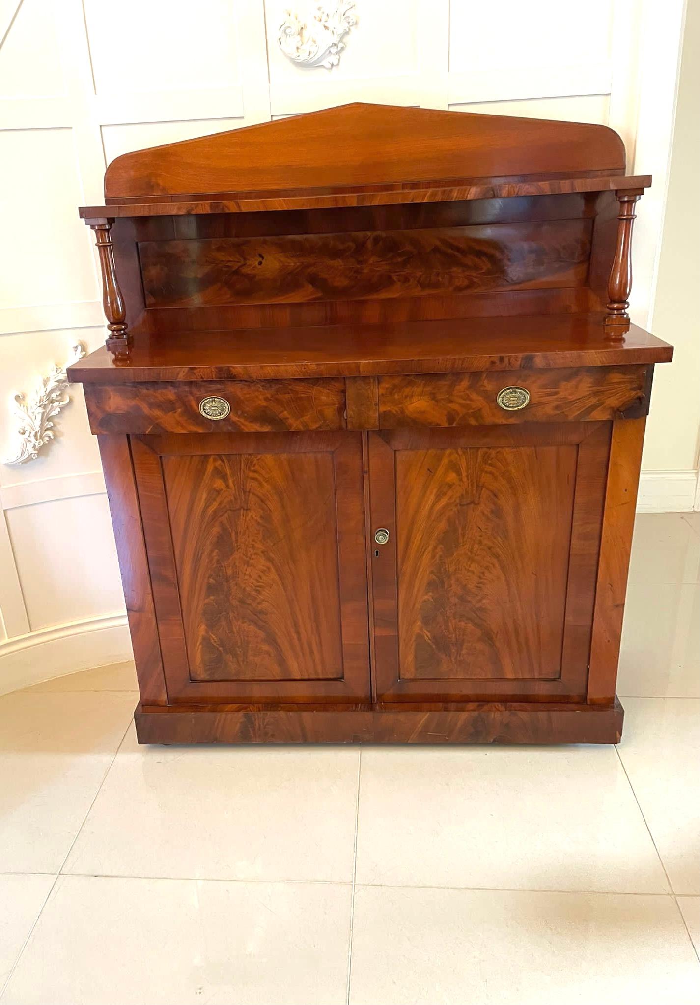 Antique William IV quality figured mahogany sideboard having a quality raised superstructure with a shelf supported by attractive turned columns above a figured mahogany sideboard with two drawers, original ornate brass oval handles, pair of figured