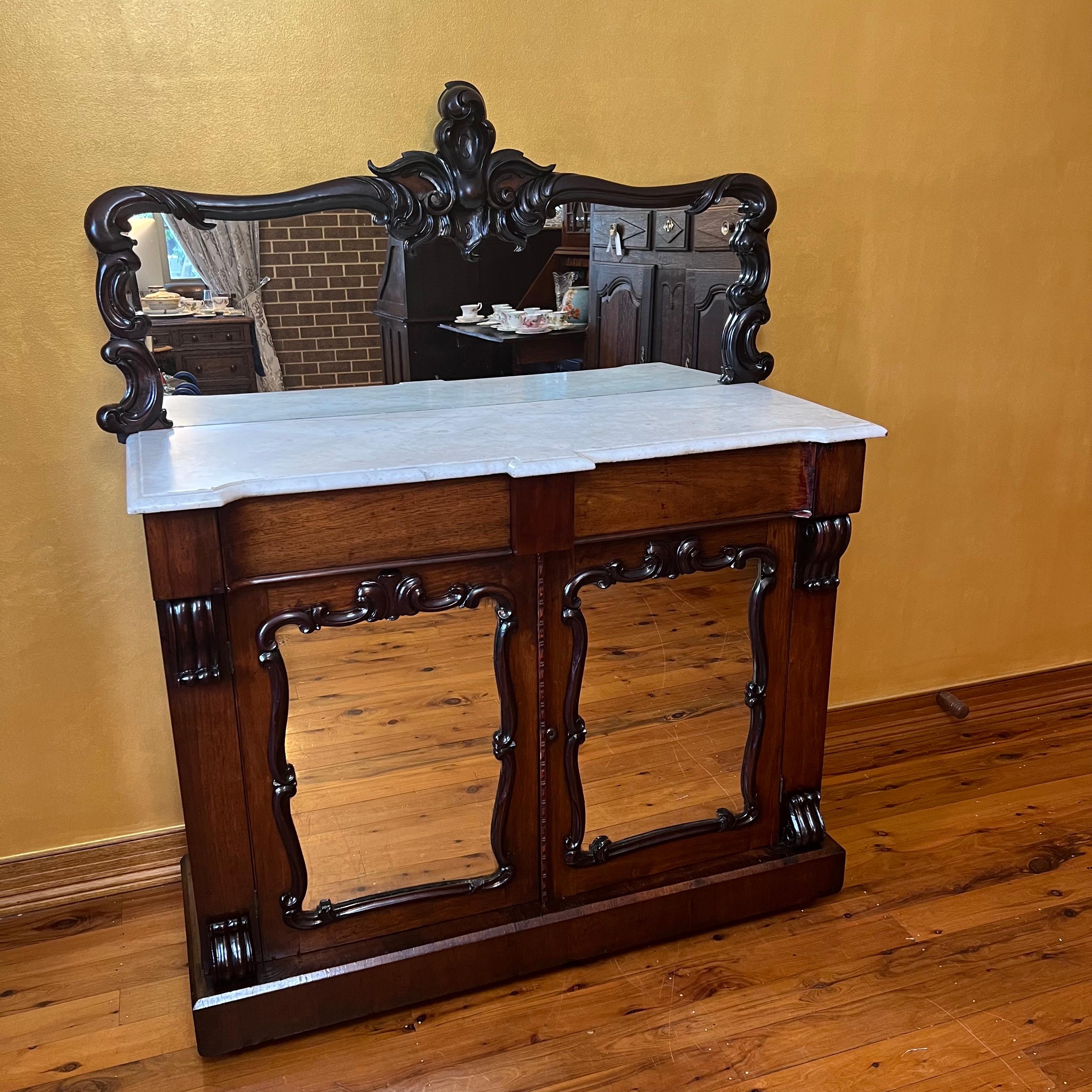 Mirrored top backboard with carved edge detail, bottom doors mirrored with two shelve inside, two drawers and marble top, marble top comes off for easier transport and movement, doesn't come with key. 

Circa: Early 19th Century 

Material:
