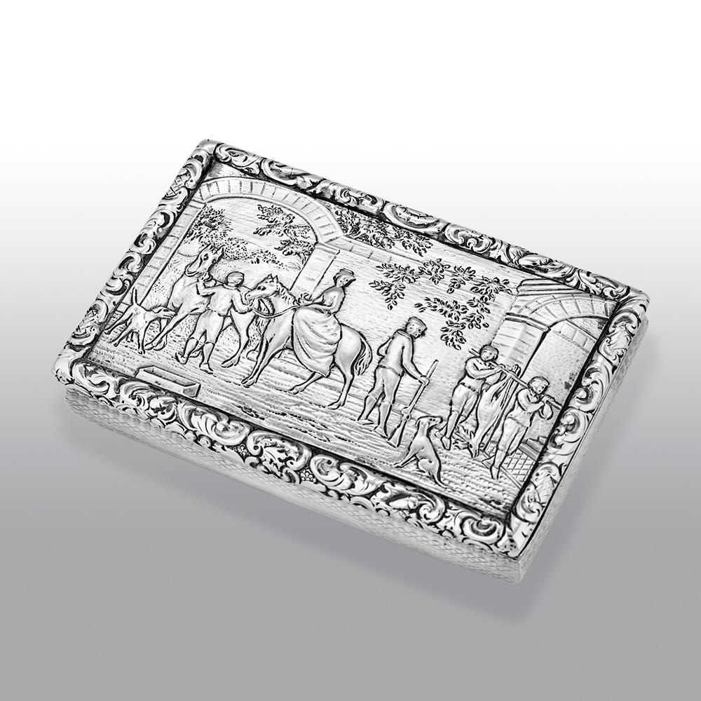 A fine William IV Scottish sterling silver snuff box of rounded rectangular form, the hinged cover depicting a fine village scene with horses, dogs and people in the courtyard, the sides and base engine-turned, the cover opening to reveal a gilt
