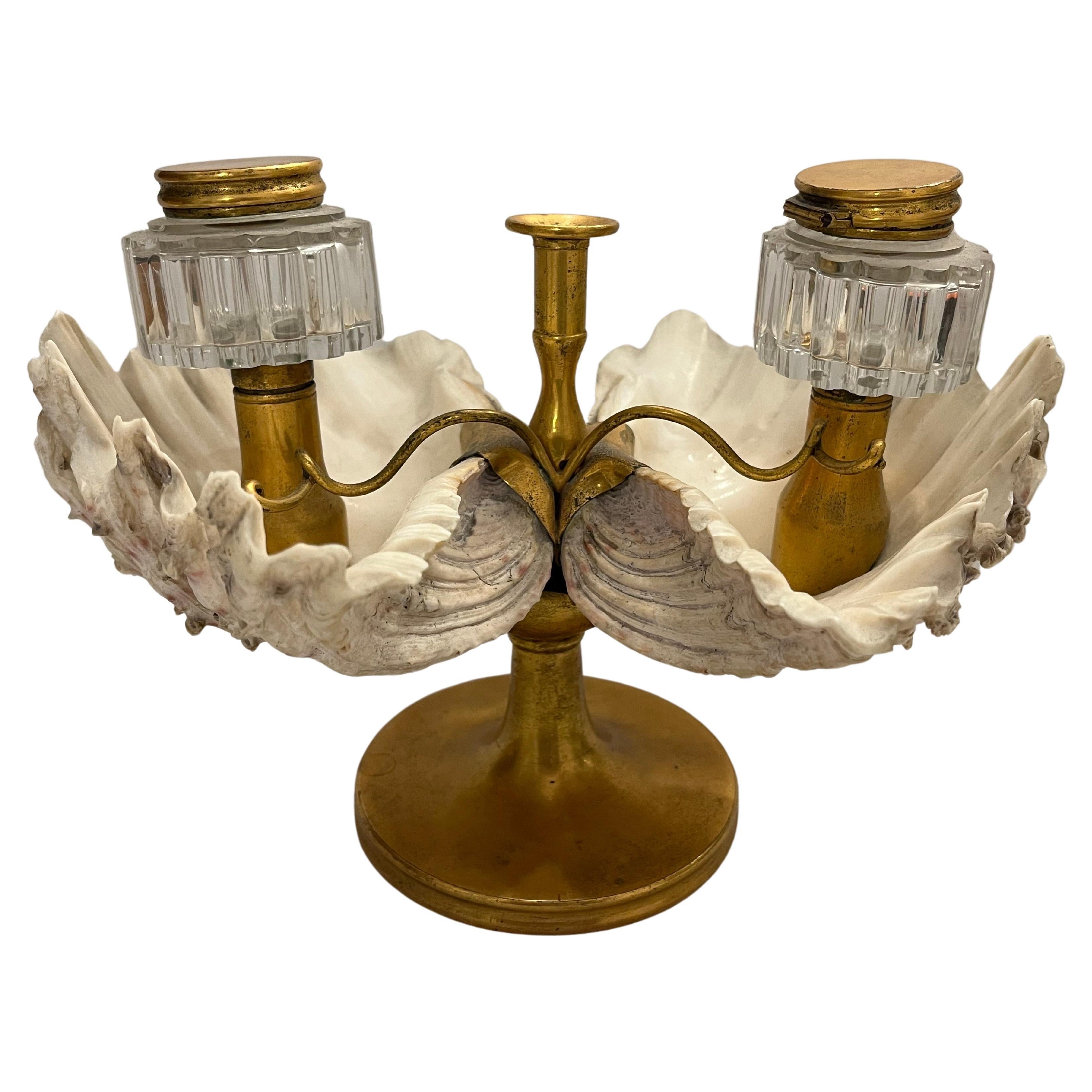 An antique, early to mid 19th Century, William IV style and period double inkwell made of natural shells and gilt bronze. The double inkwell features two scalloped fluted glass containers complete with hinged lids, a scrolled arm pen rest and a