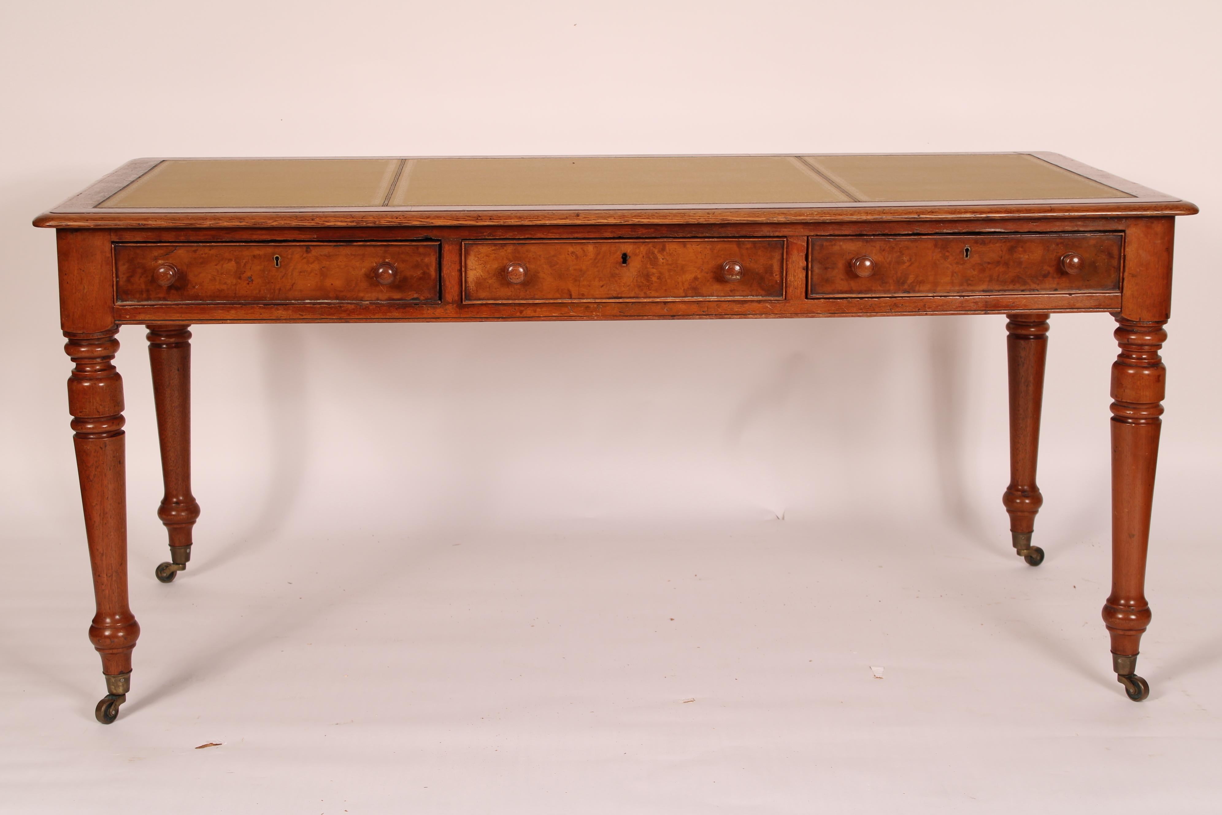 William IV oak and pollard oak writing table with a tooled leather top, 19th century. The top with an inset tooled leather top with pollard oak banding and oak molded edges, 3 oak frieze drawers with cock beaded moldings and wood knobs, resting on