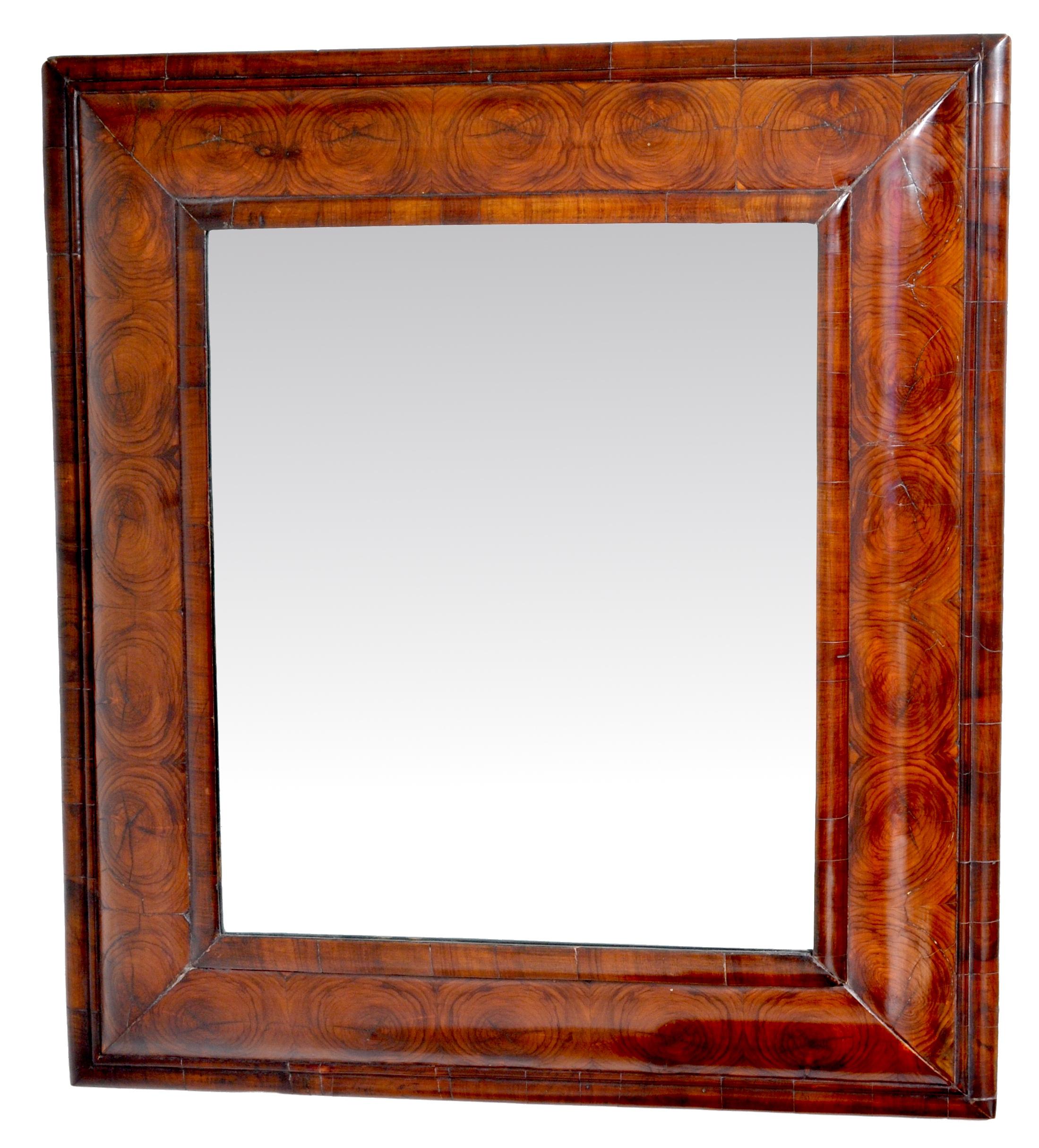 Antique William & Mary Laburnum oyster veneer cushion-shaped mirror, circa 1690. A fine William and Mary oyster veneered mirror from 1690, the rectangular mirror plate within a cushion-molded frame and having finely cut oyster-shaped molding. The