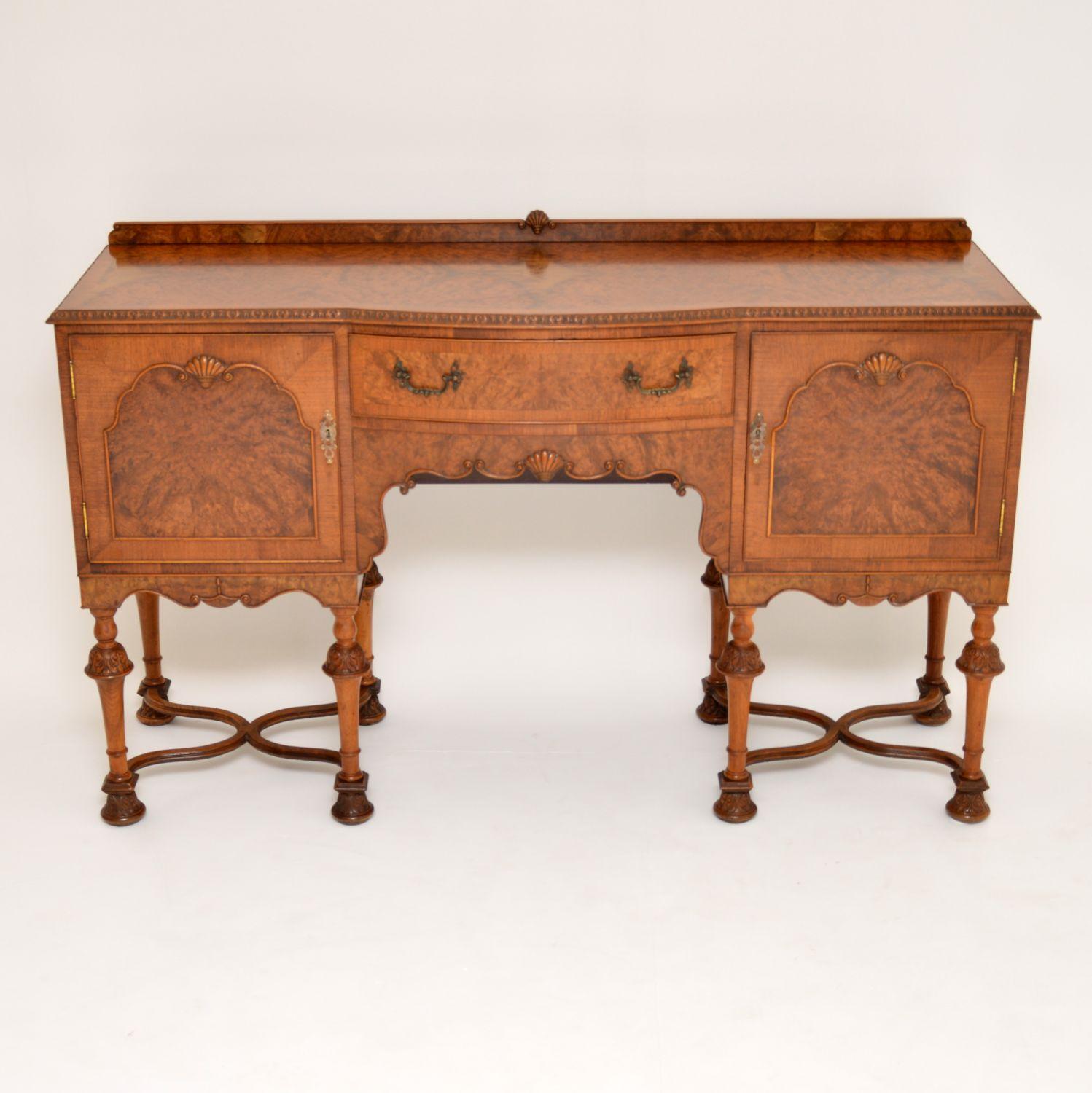 Antique William & Mary style walnut sideboard of incredible quality and dating to circa 1930s period. It has a burr walnut top with a crossbanded edge and fine carving all around. There are two burr walnut panelled cupboards with shell carvings on