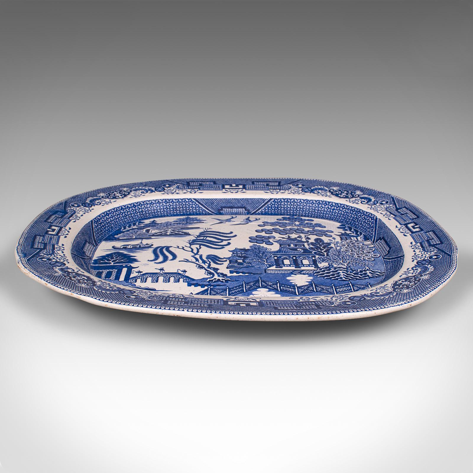 This is an antique Willow Pattern serving plate. An English, ceramic decorative meat dish, dating to the Victorian period, circa 1850.

Accentuated with the enduring appeal of the classic Willow Pattern decor
Displays a desirable aged patina and in