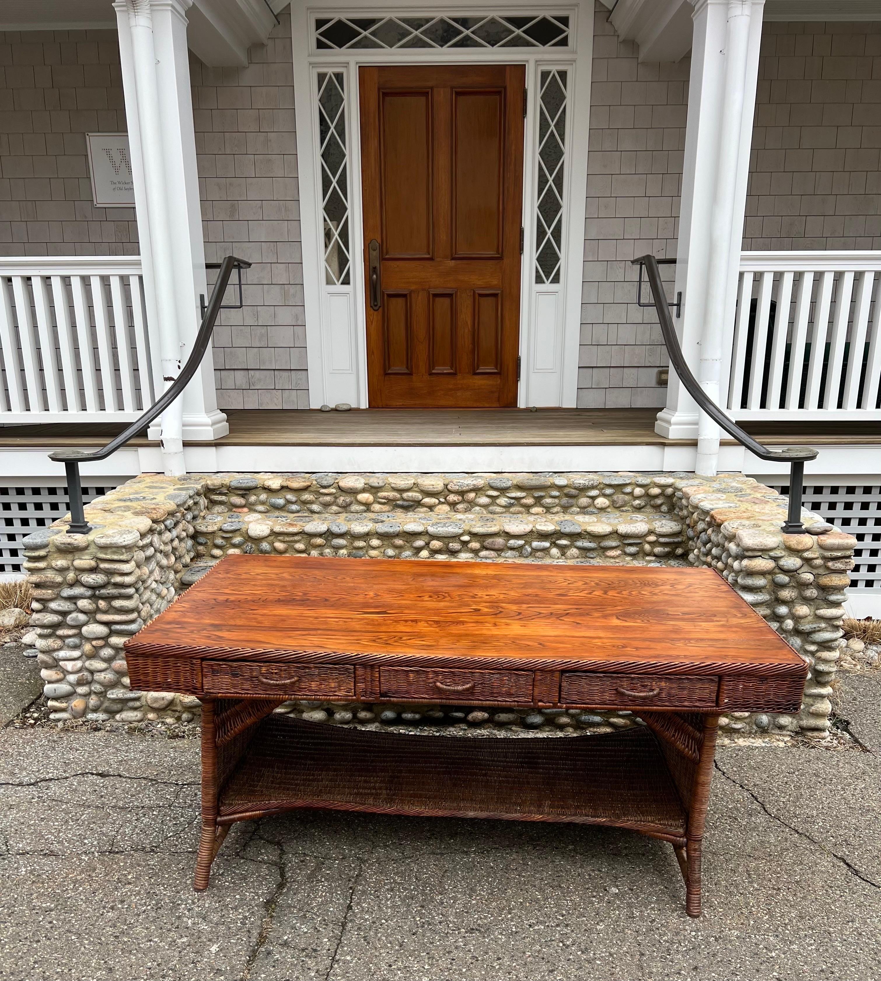 An antique writing desk woven of willow in a rich natural stain finish. The quarter sawn oak top has beautiful detail and color. An exceptional, rare find. This desk measures 67” by 37” and stands 30” tall.