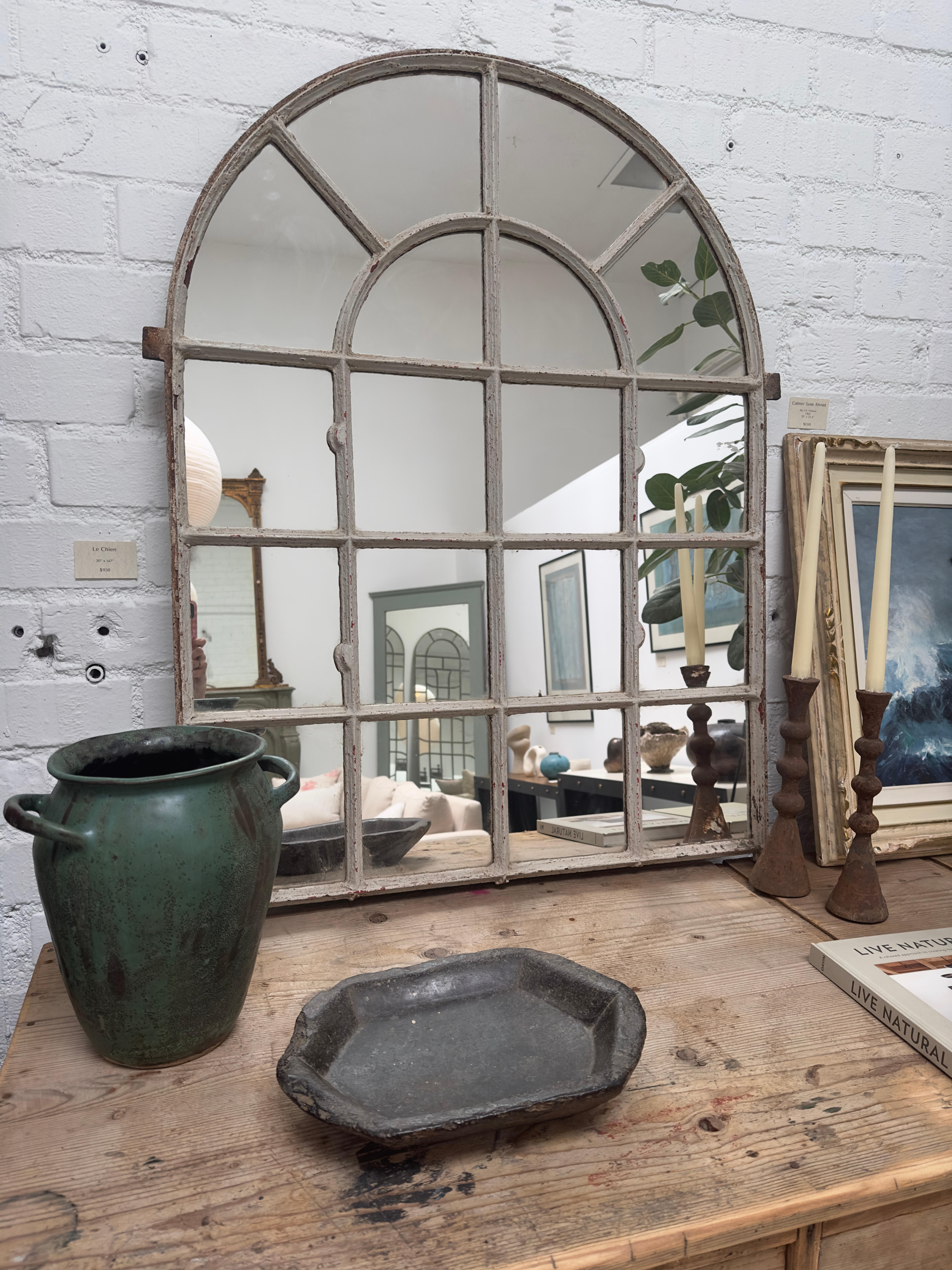 This charming Antique Window Mirror is a beautiful blend of rustic character and timeless elegance. Featuring an arched top and divided panes, it evokes the look of an old-world window, bringing a touch of history and depth to any space. Its