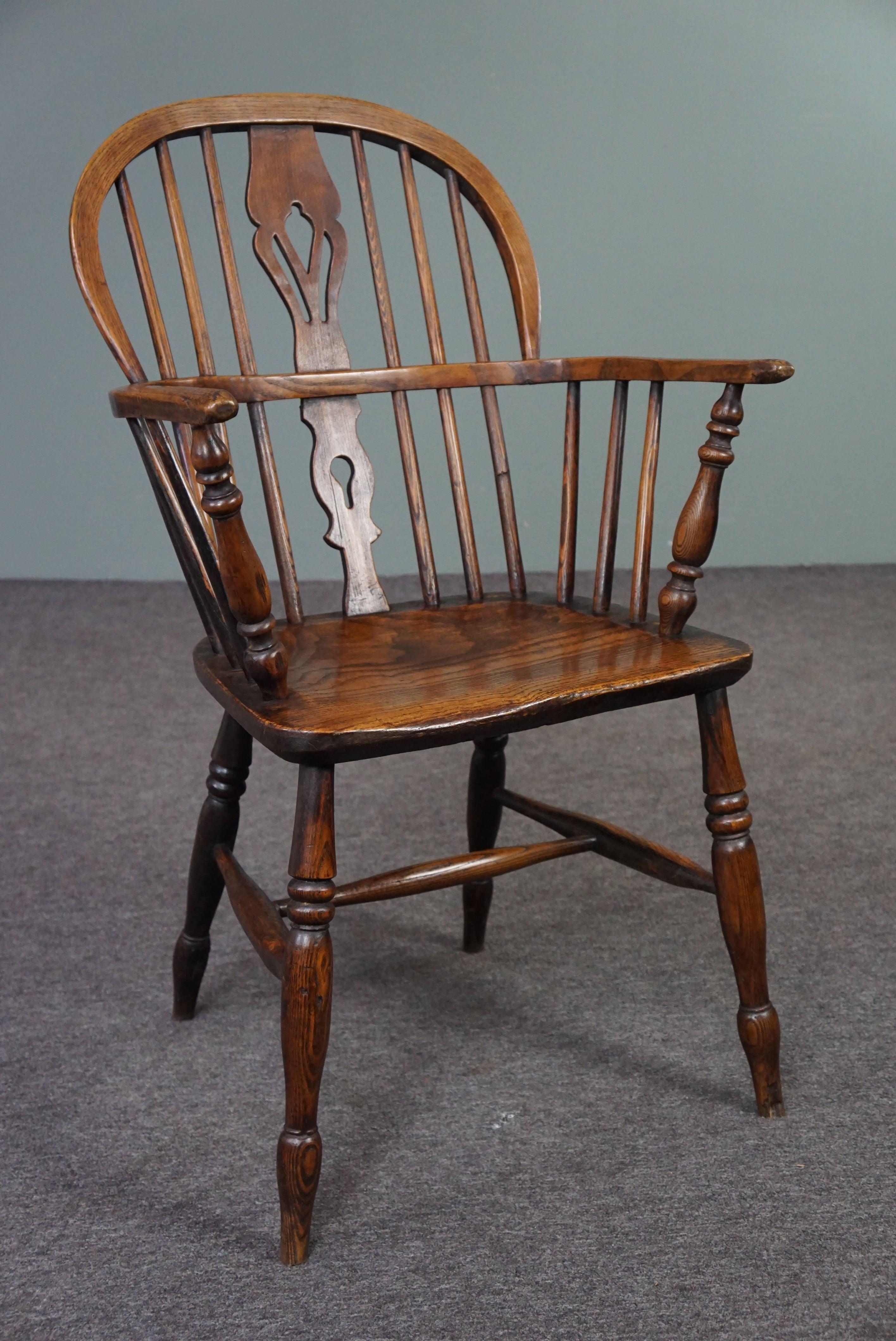 Offered is this beautiful antique armchair made of solid wood with a very beautiful characteristic appearance.

This striking English antique Windsor armchair with armrests has a well-shaped thick solid wooden seat. The chair has charming turned
