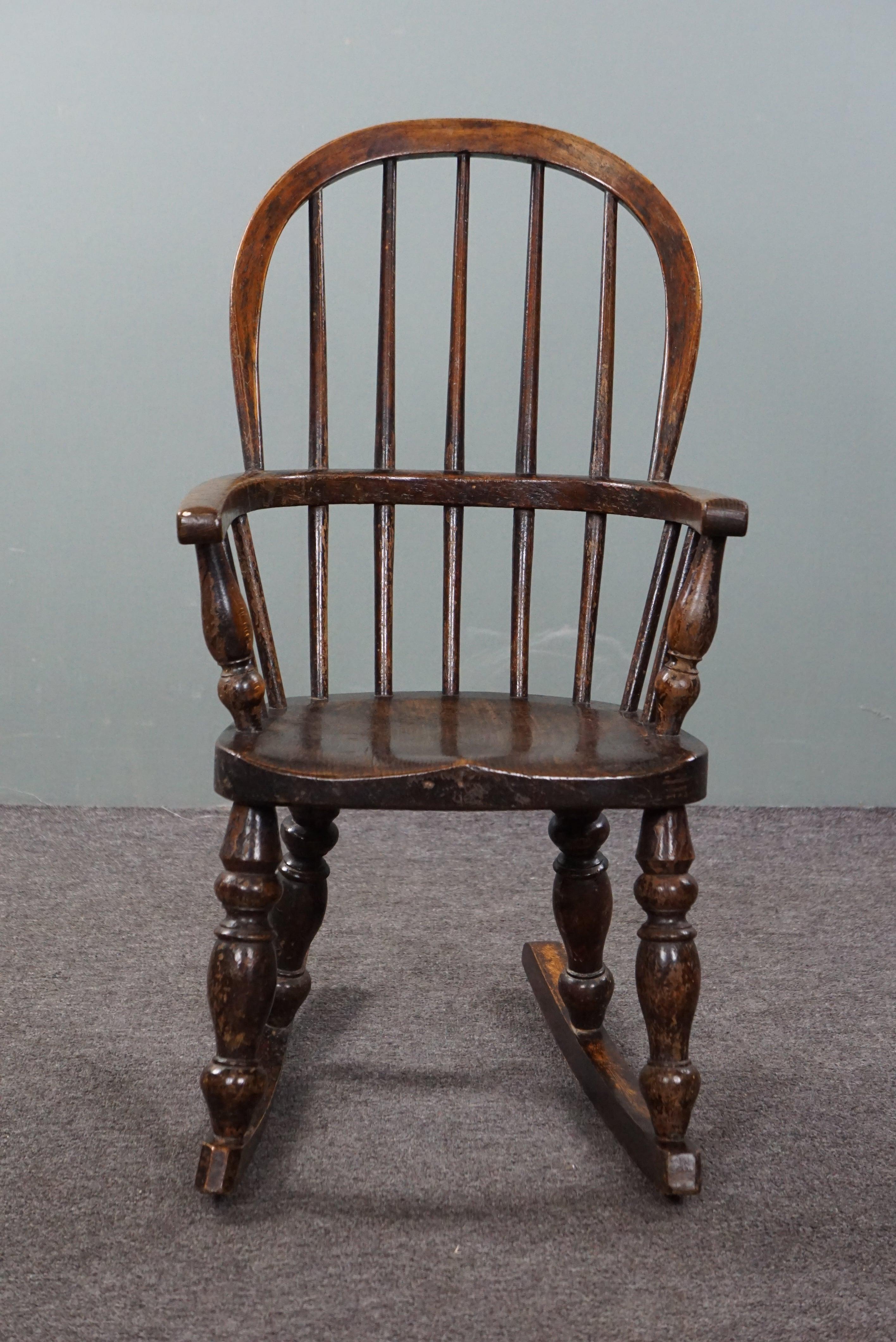 Offered is this antique Windsor rocking chair in a child's size. The charming allure of this chair from the early 19th century reflects a bygone era and brings a touch of history into the (children's) room. The unique design and beautiful details