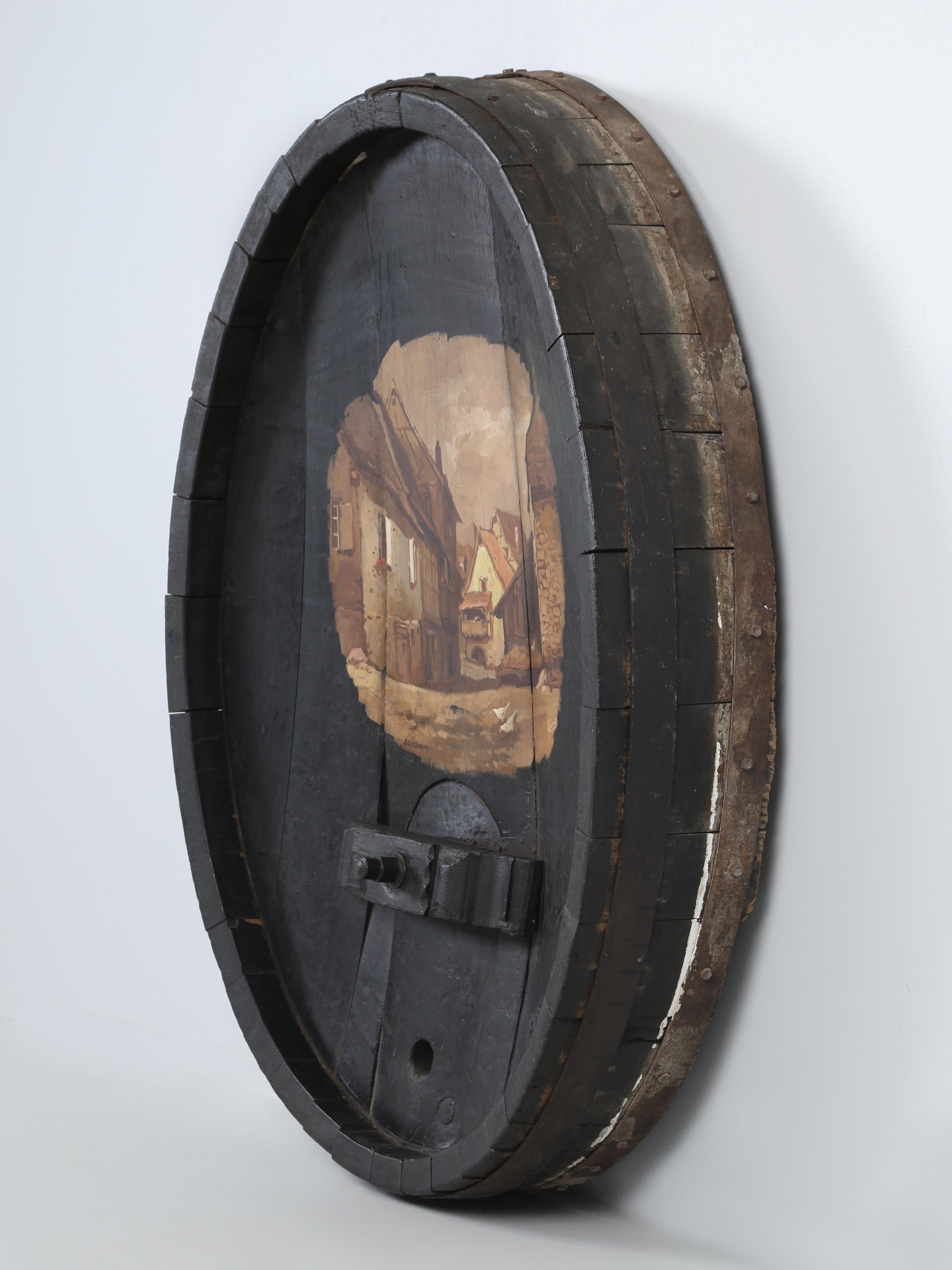 Antique Wine Barrel End Cap that was repurposed into an unusual piece of Wall Art that would be ideal for a Wine Room. The painting itself is of the old town of Eguisheim, France which is a medieval village, complete with castles in the famous