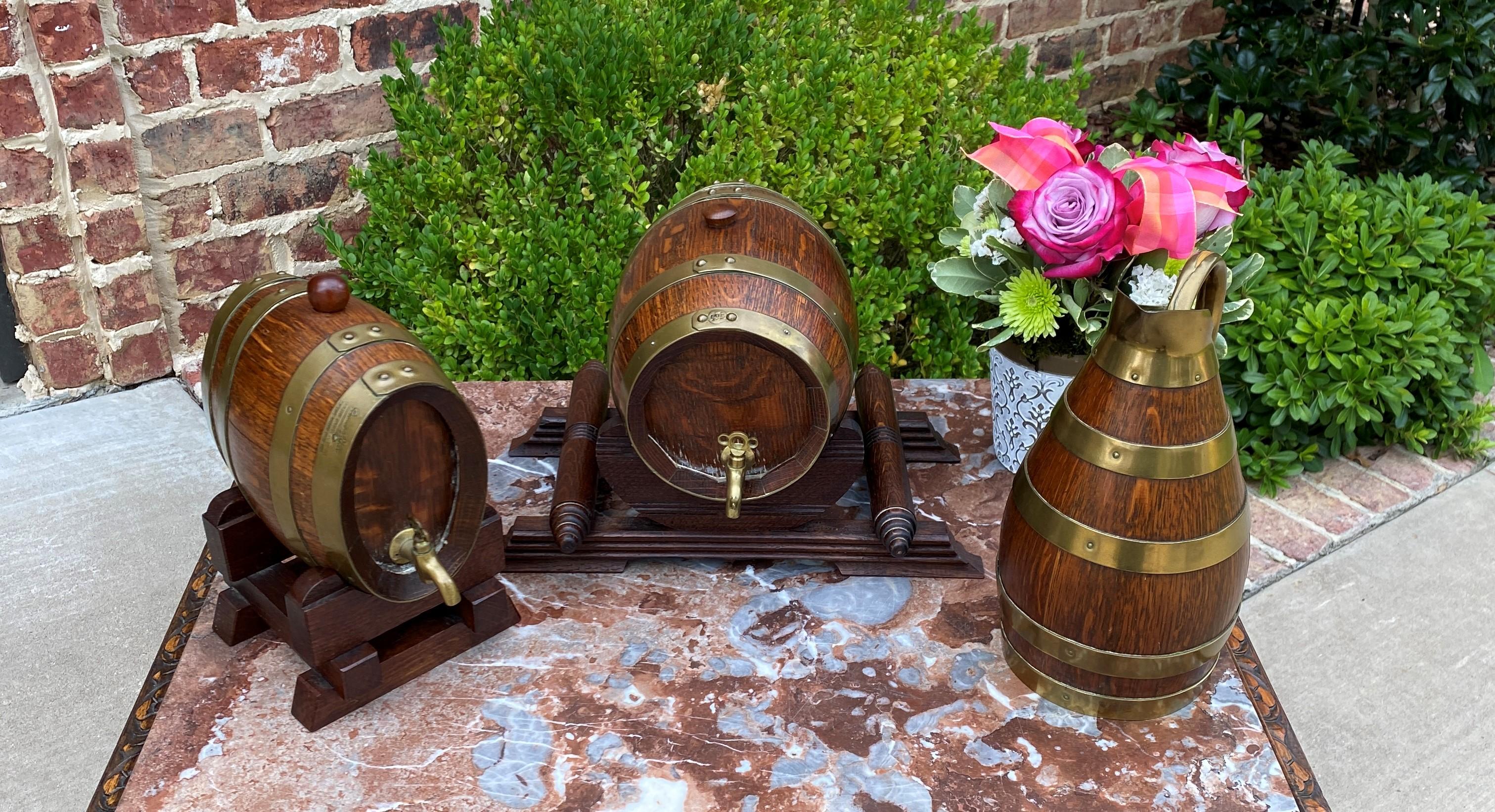Unique set of 3 antique oak brass banded wine barrels or casks with matching pitcher/jug~~Maker's Hallmarks~~c. 1920s 
 
Two sturdy oak barrels or casks with brass banding, brass spigots and cradles~~also included is the matching pitcher or