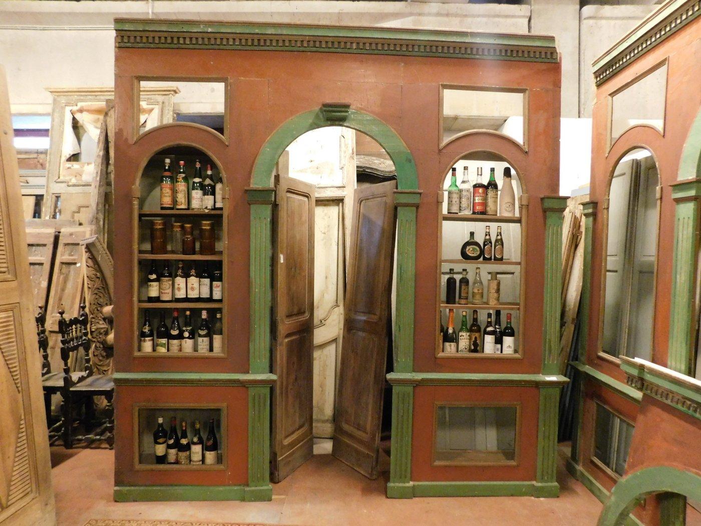 Antique furniture for a wine cellar, divided into two wall bodies that were joined by an arch with passage, has typical colors of the vines: red and green, composed of lacquered wood. Beautiful and complete it was used in a shop that sold wine in