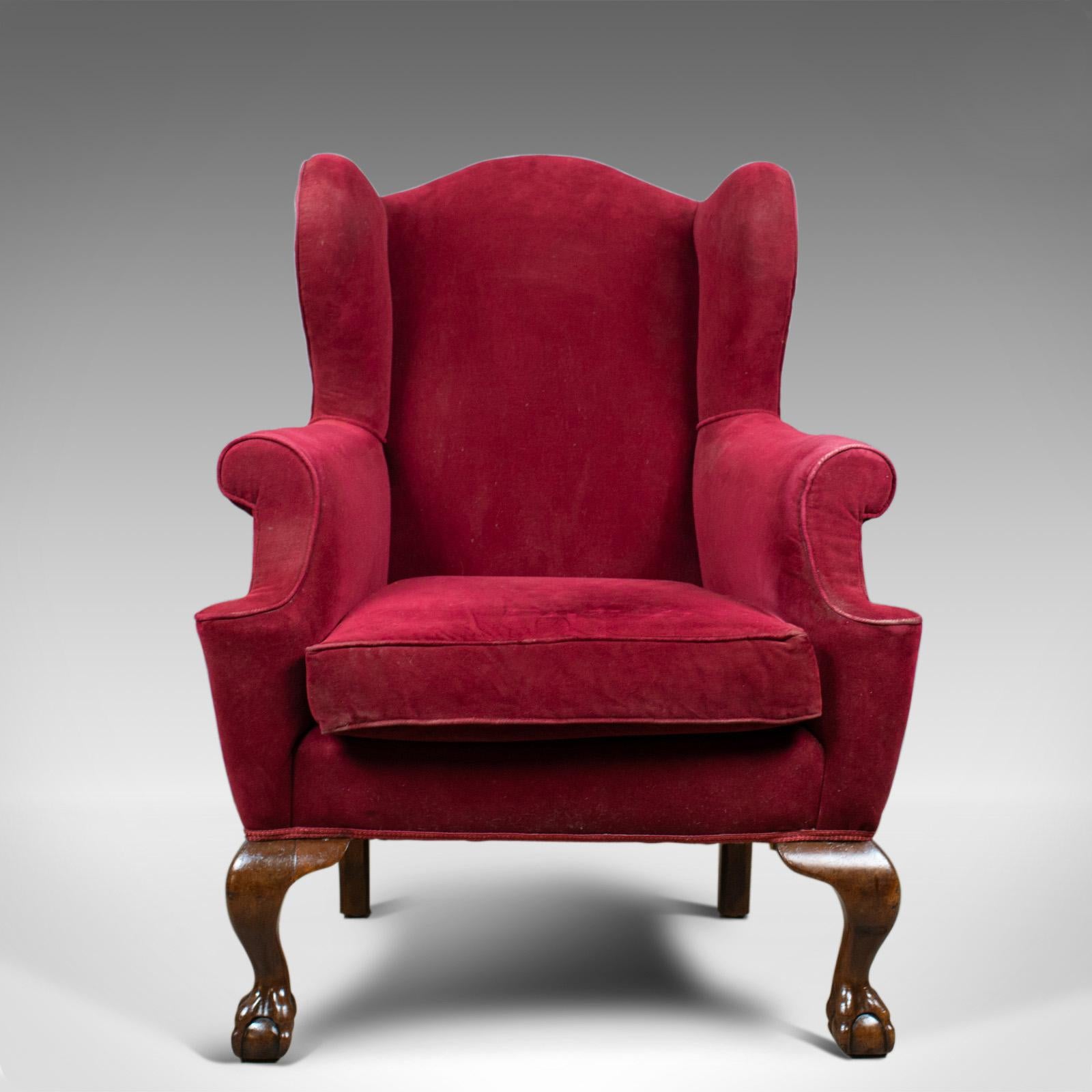 This is an antique wing back armchair. An English, late Victorian chair dating to the turn of the 20th century, circa 1900.

A large comfortable seat with loose cushion
Well sprung and professionally upholstered
Finished in a claret velour cloth