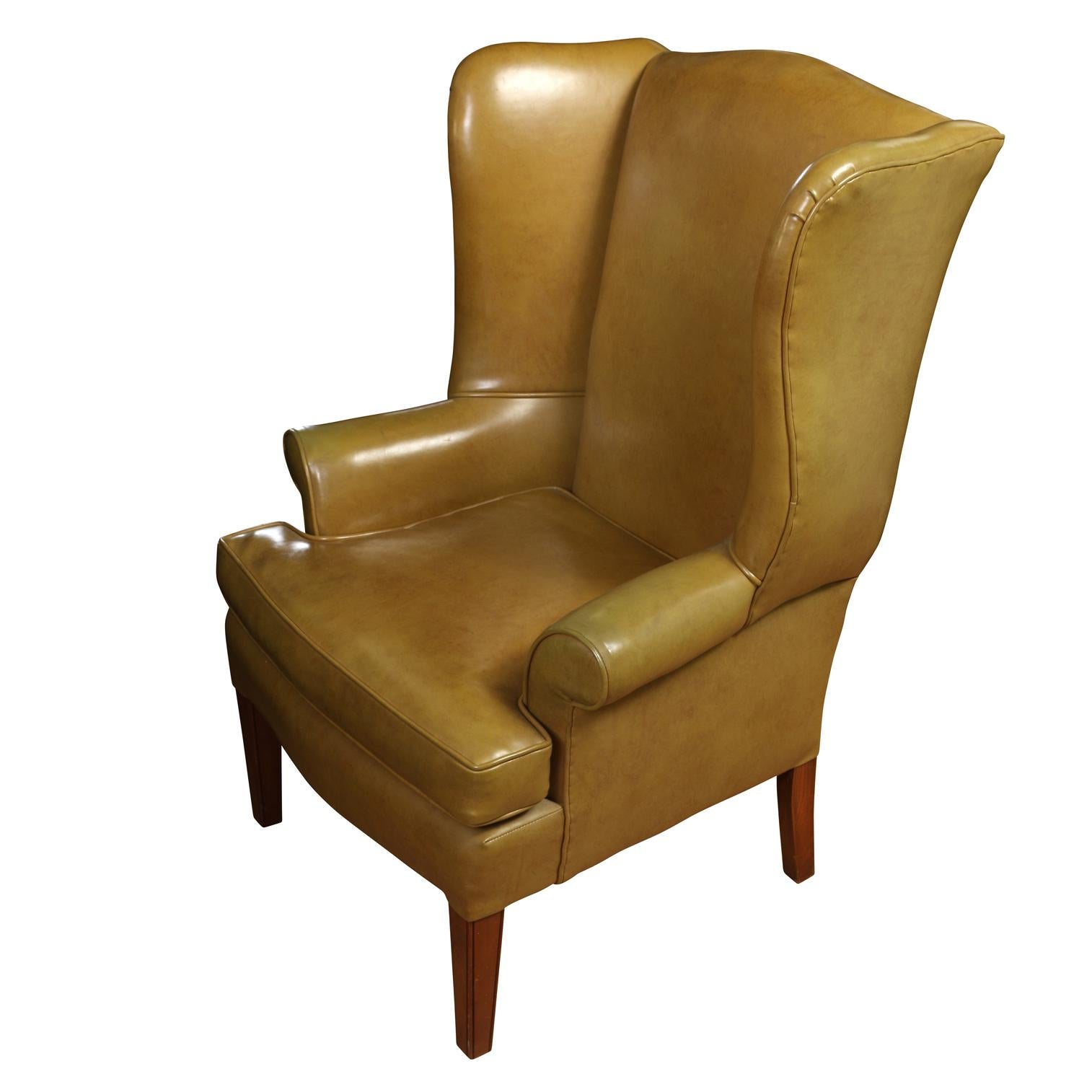 A vintage wingback chair in a natural leather look upholstery on straight legs