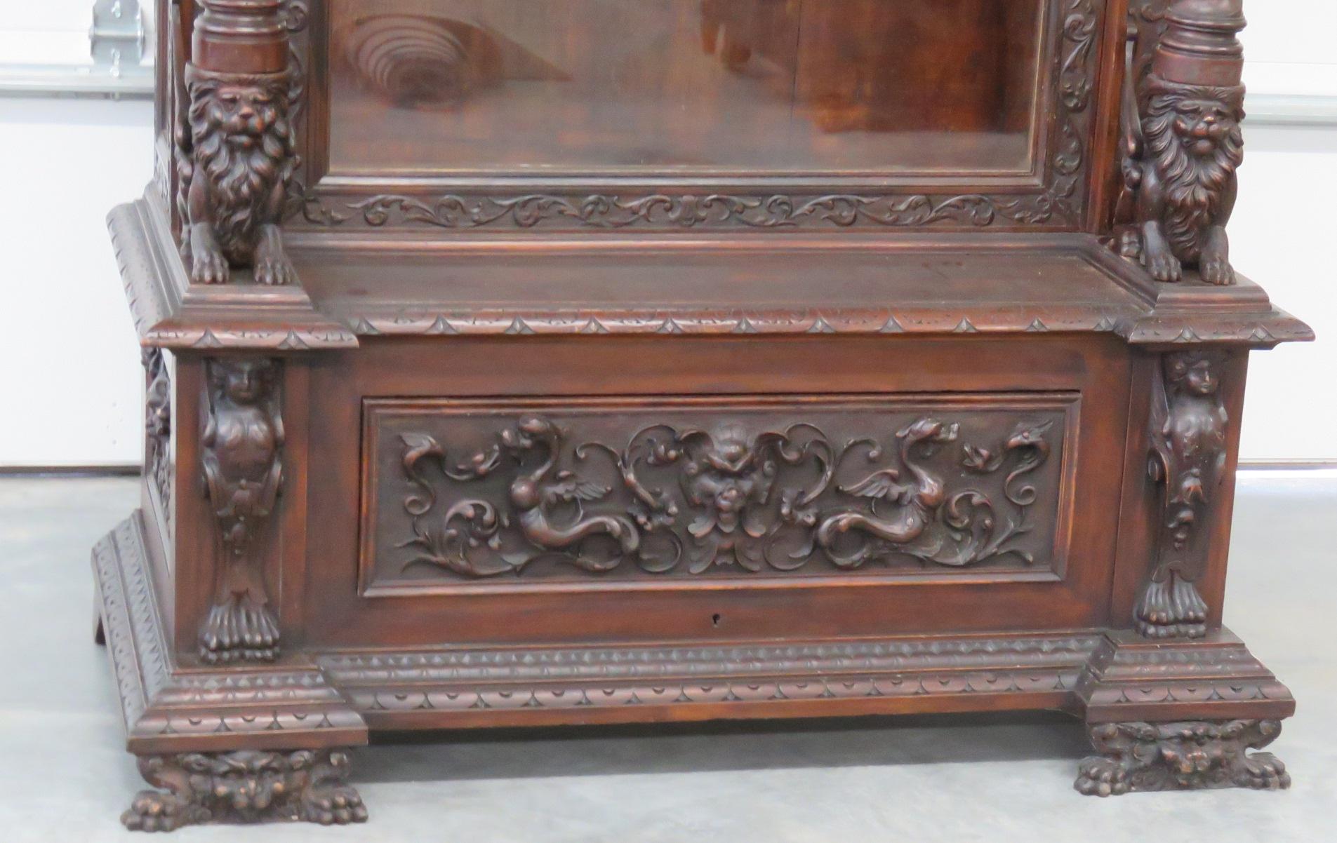 Antique winged griffin carved china cabinet with one door containing 3 shelves over 1 drawer.