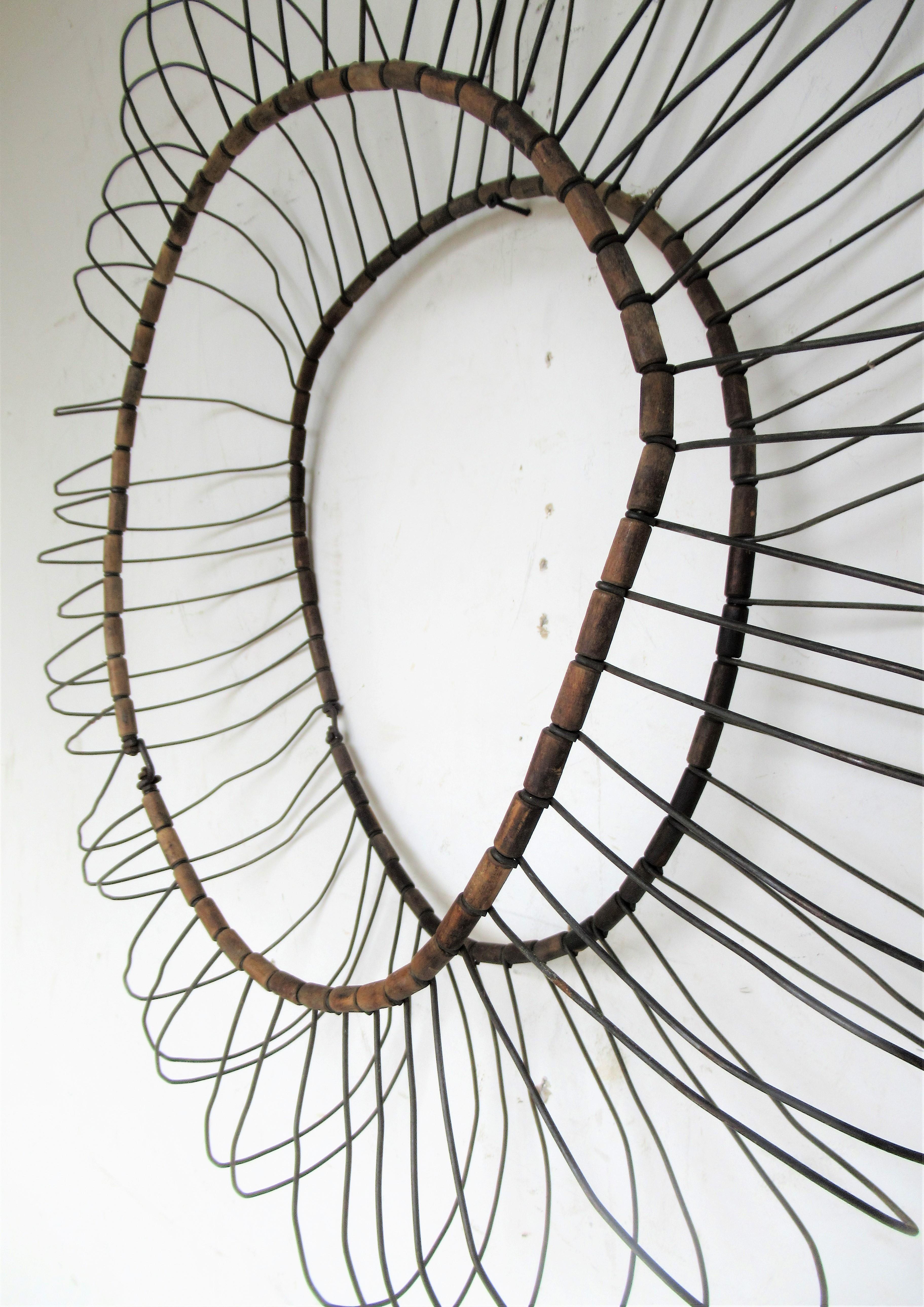 Three dimensional antique wire and cylindrical wood links large sunburst / flower petal form with great sculptural quality. Initial use was a cage to hold an old inner tube for a tire.  Circa 1930. A great looking object to display as decorative