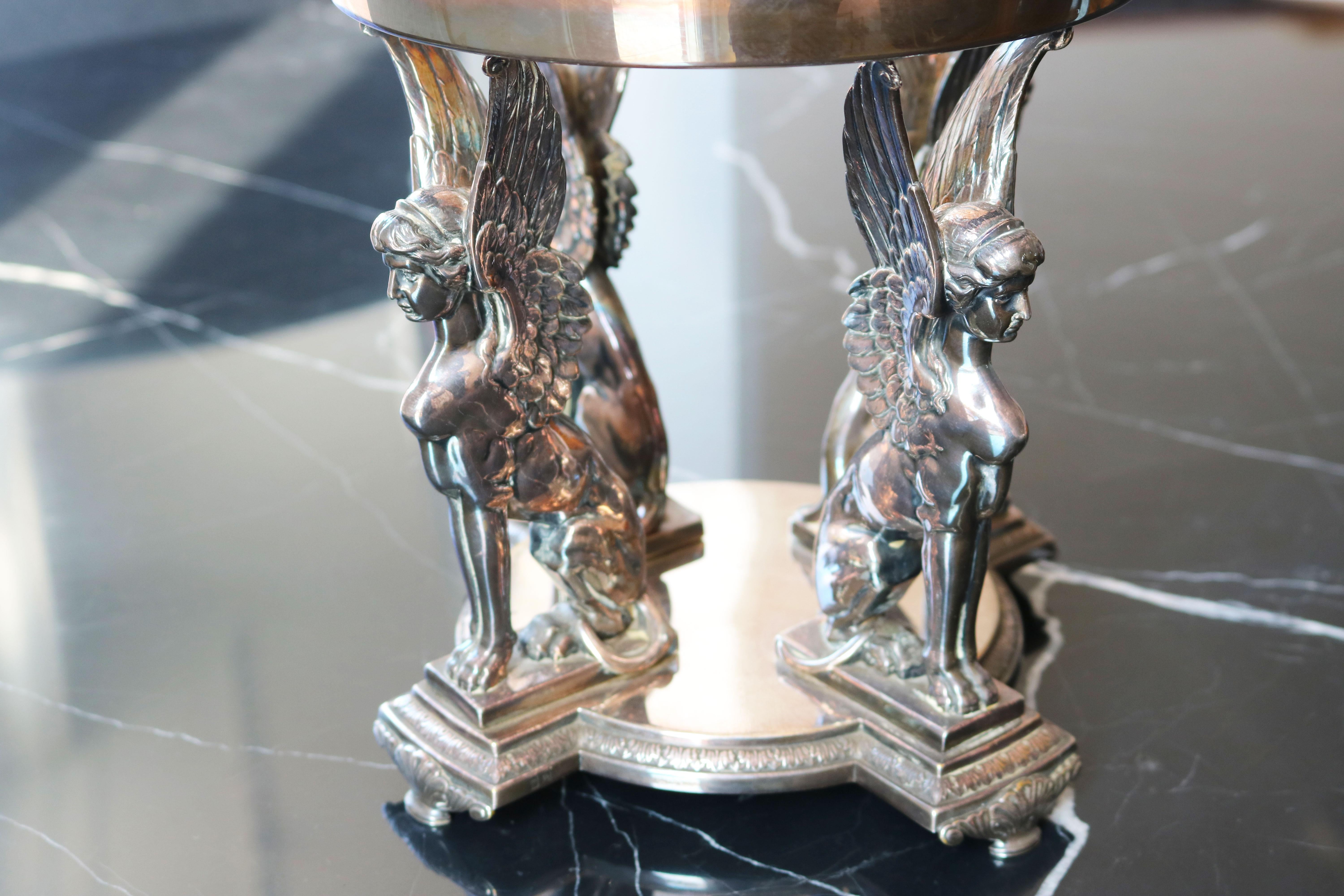 Precioso centro de mesa WMF Art Nouveau de cuatro esfinges aladas (Renacimiento egipcio). 
Este centro de mesa fue fabricado en Alemania por los mundialmente famosos metalistas de la empresa WMF (WURTTEMBERGISCHE METTALWARENFABRIK) hacia 1900. 
El