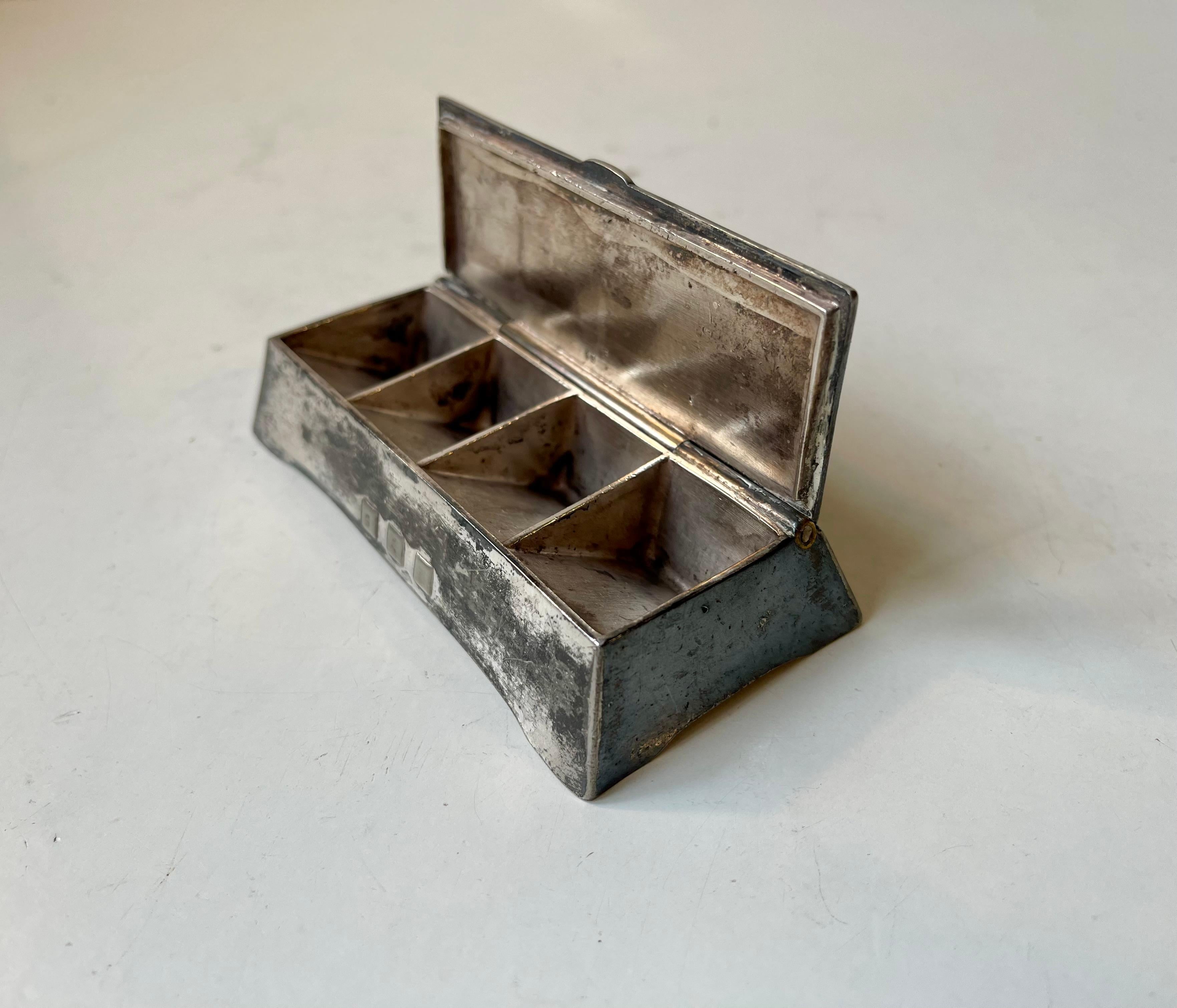 A 4 compartment container for stamps or pills. Distinct jugend - art nouveau styling. Made by WMF in Germany circa 1910-20. Raw undisturbed patina - un-polished. 

Measurements: 10x4x2.5 cm.