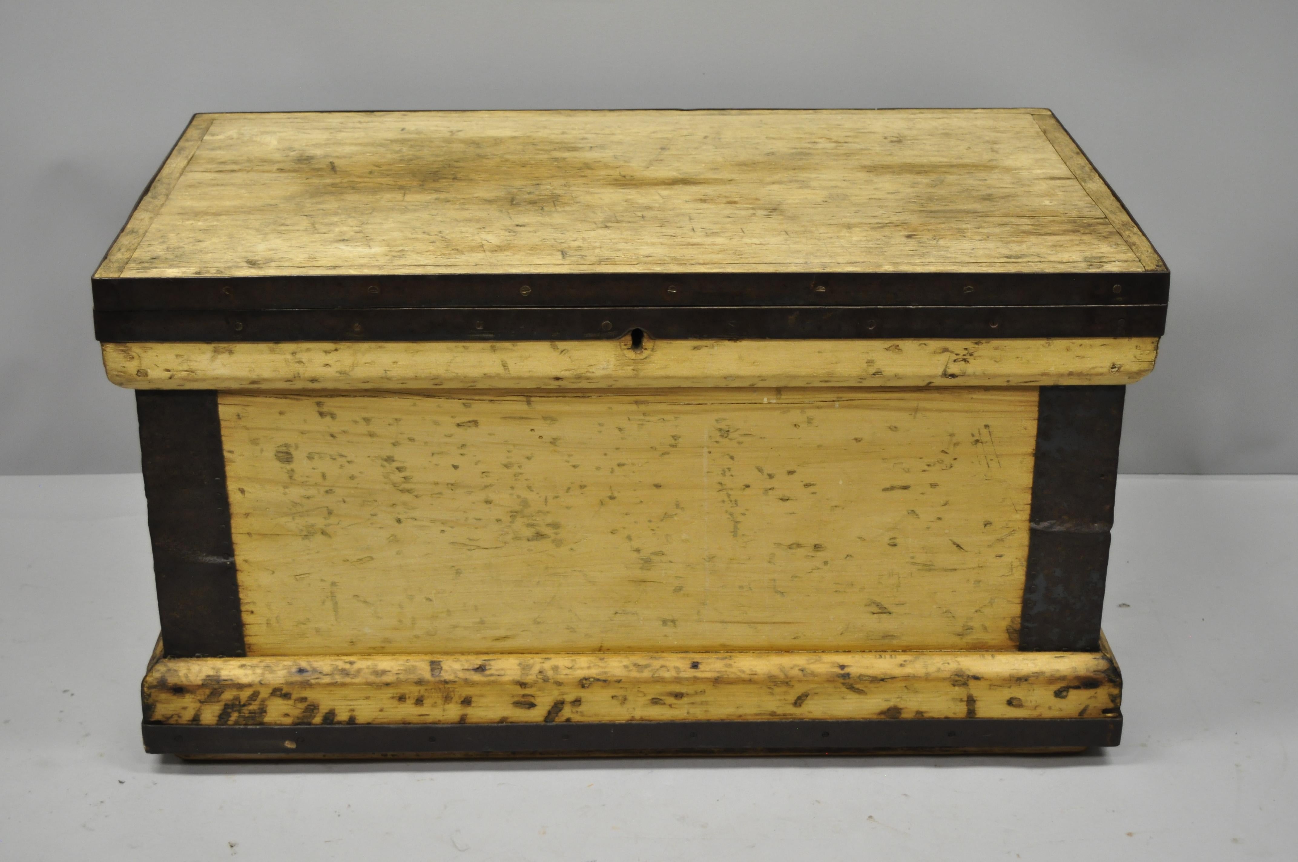 Antique wood and cast iron primitive industrial trunk blanket storage chest. Item features heavy solid wood construction, cast iron trim, side handles, desirable weathered finish, lock removed for safety. Weighs approximate 80 pounds, circa 19th