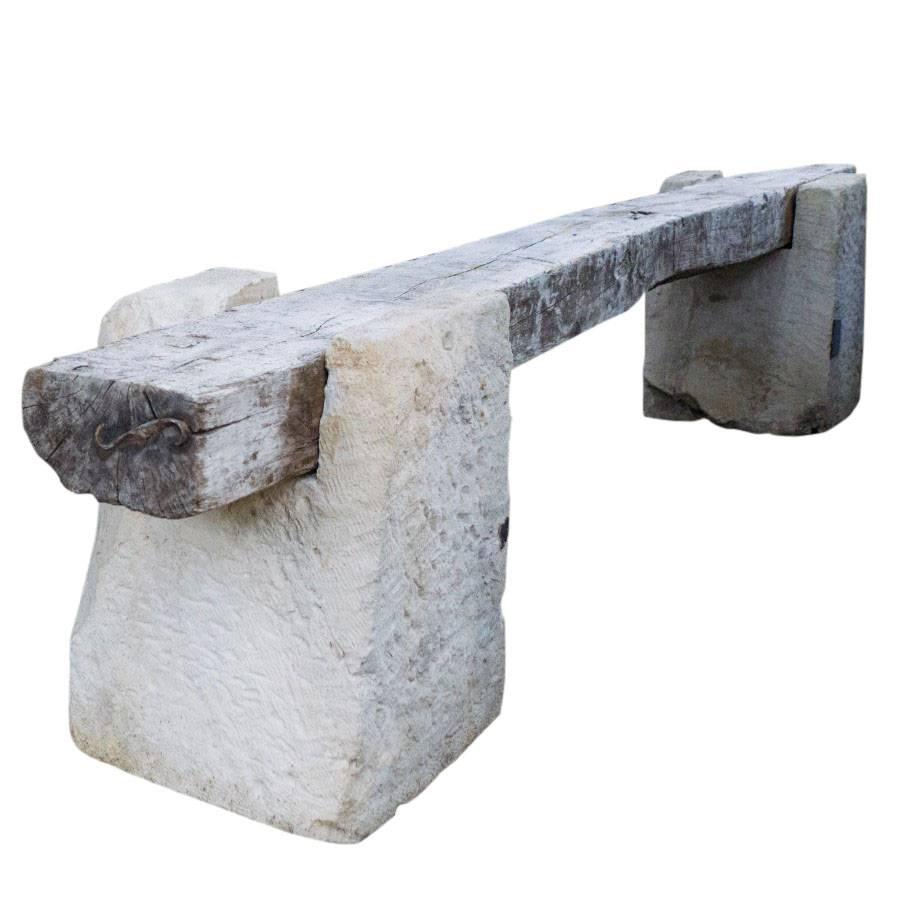 Carved stone legs reinforce the solid thick rectangular wood bench. Purchased in France and exported to California.