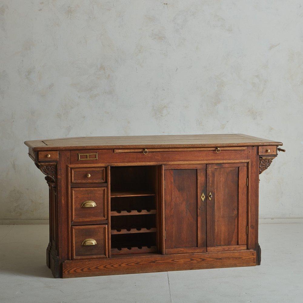 A handsome antique French wood cabinet or buffet constructed with wood. This piece offers ample storage space, with three drawers on the left hand side, one cabinet with doors on the right hand side with one shelf, and a center open shelf with built