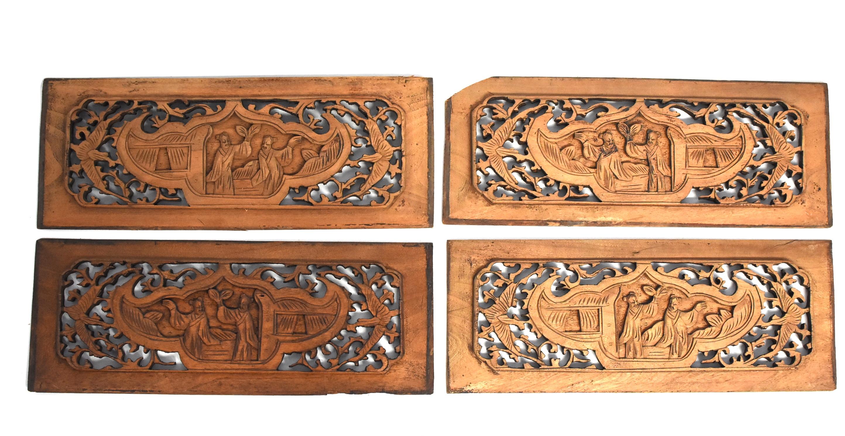 A wonderful set of four 19th century wood carvings each featuring two scholars in a garden pavilion. A combination of relief carving and pierced carving techniques are used in these pieces. The center in a treasure pot shape flanked by butterflies