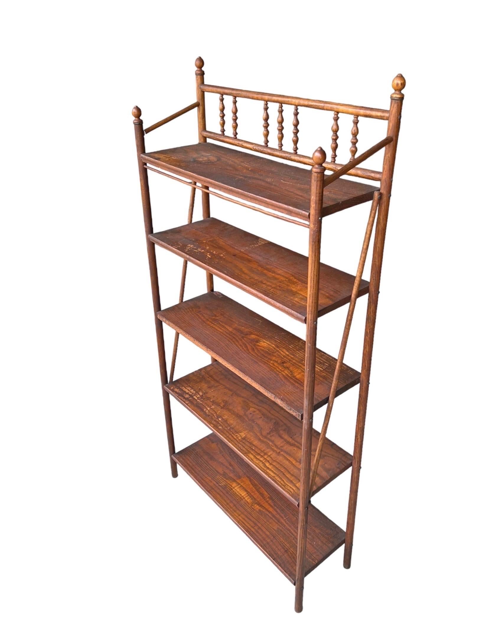 This is an antique etagere. The Victorian era wood stand features turned detailing and five open shelves.
In good condition with wear as noted in pictures and consistent with age and use. 

( Available by Online Purchase Only)

 Dimensions. 26W 9D