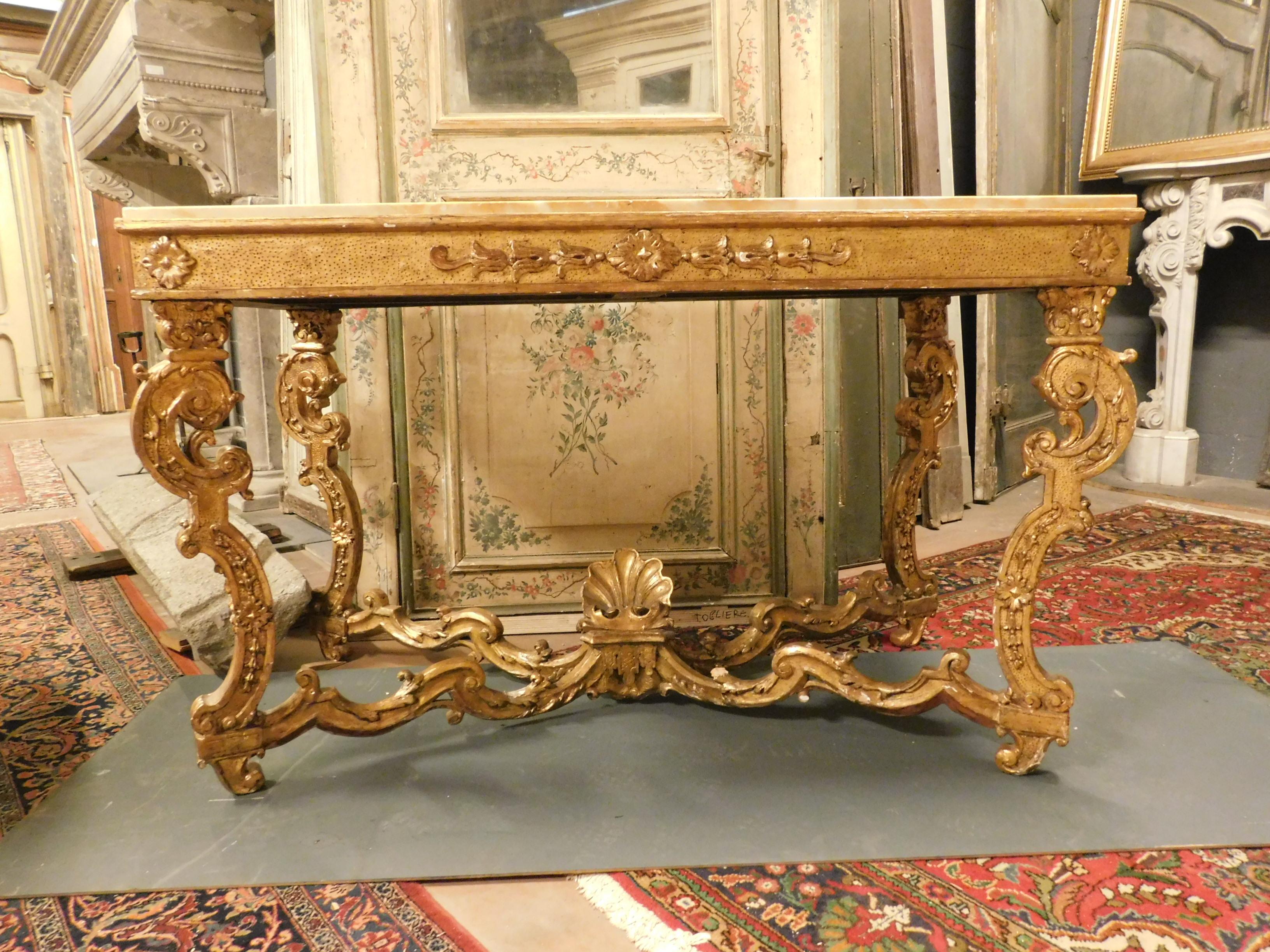 Antique gilded console table, in wood with richly carved legs like the style of the time, with yellow marble top, measuring cm W 141 x H 90 x D 70. It comes from a rich castle in southern Italy, from Naples, recognizable the typical taste, very