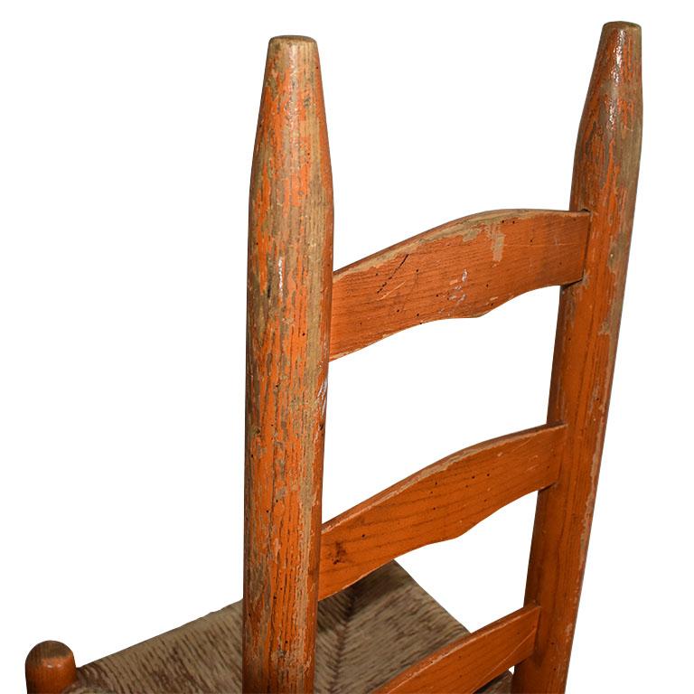 American Craftsman Chaise d'appoint pour enfant en bois ancien avec dossier en échelle et siège en jonc peint en orange en vente