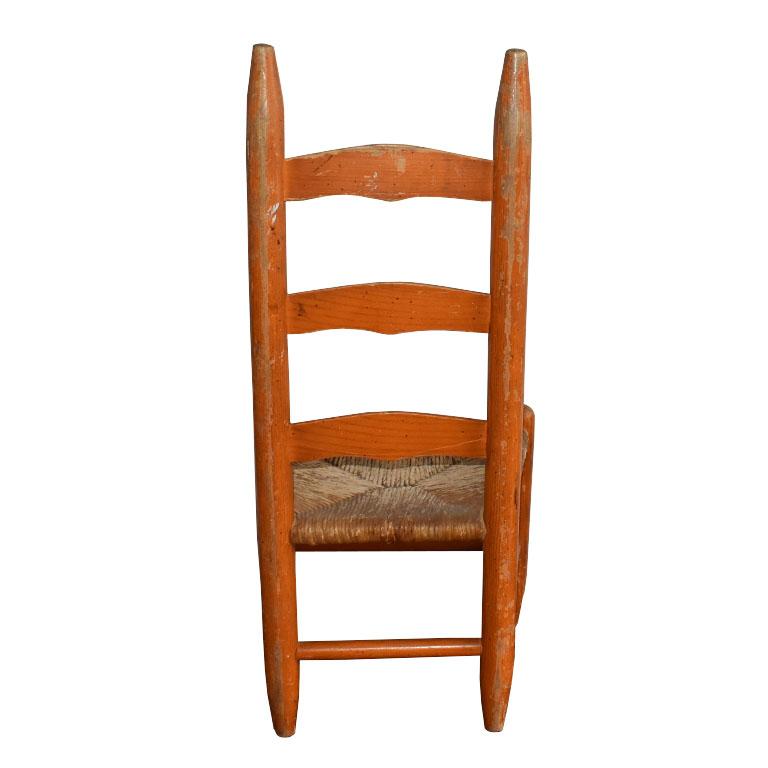 Américain Chaise d'appoint pour enfant en bois ancien avec dossier en échelle et siège en jonc peint en orange en vente