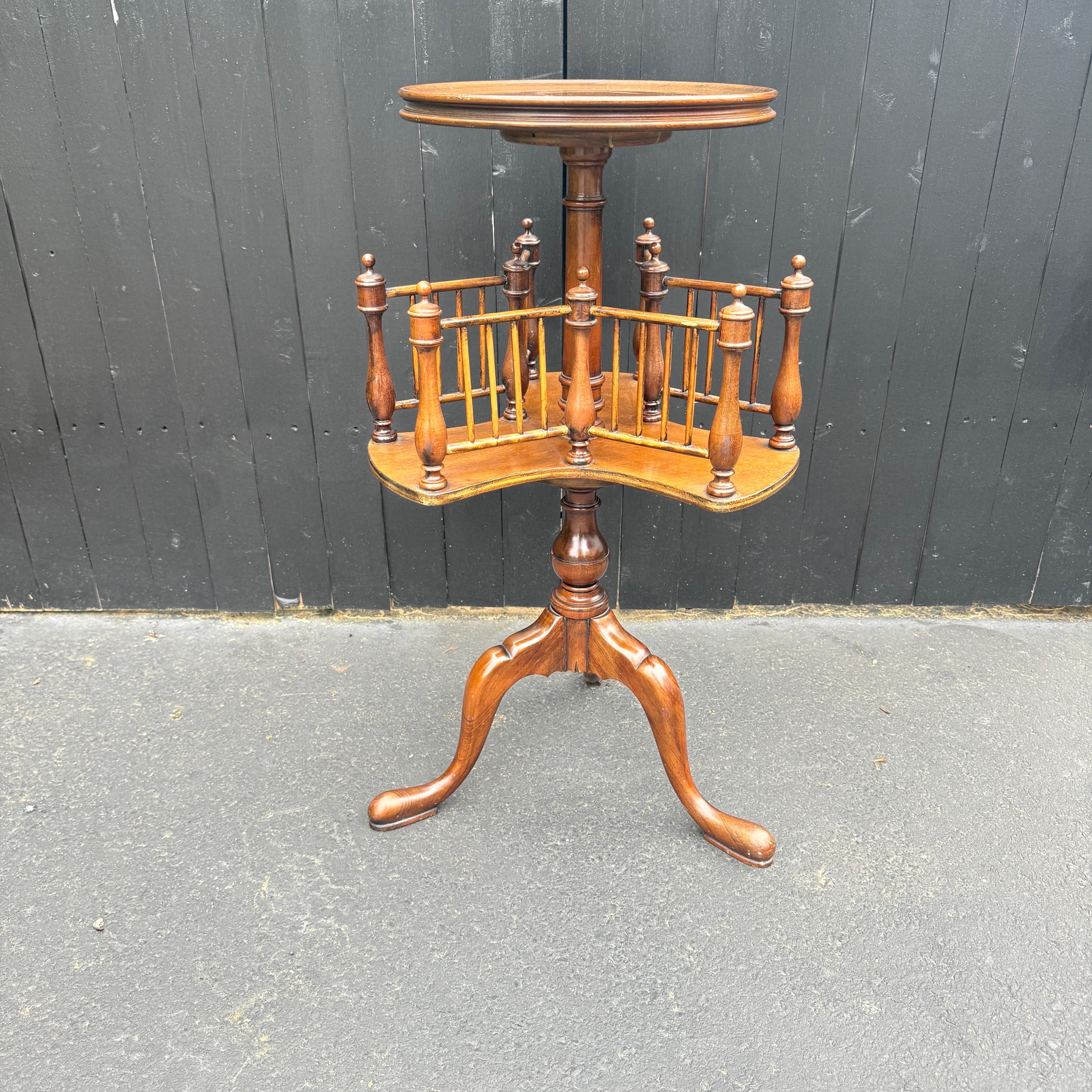 Wood revolving book table with circular top and molded edge. This revolving bookshelf with dividers is raised up on a tripod base. Fantastic vintage piece that could be used in a living room setting as well as next to your favorite leather chair in