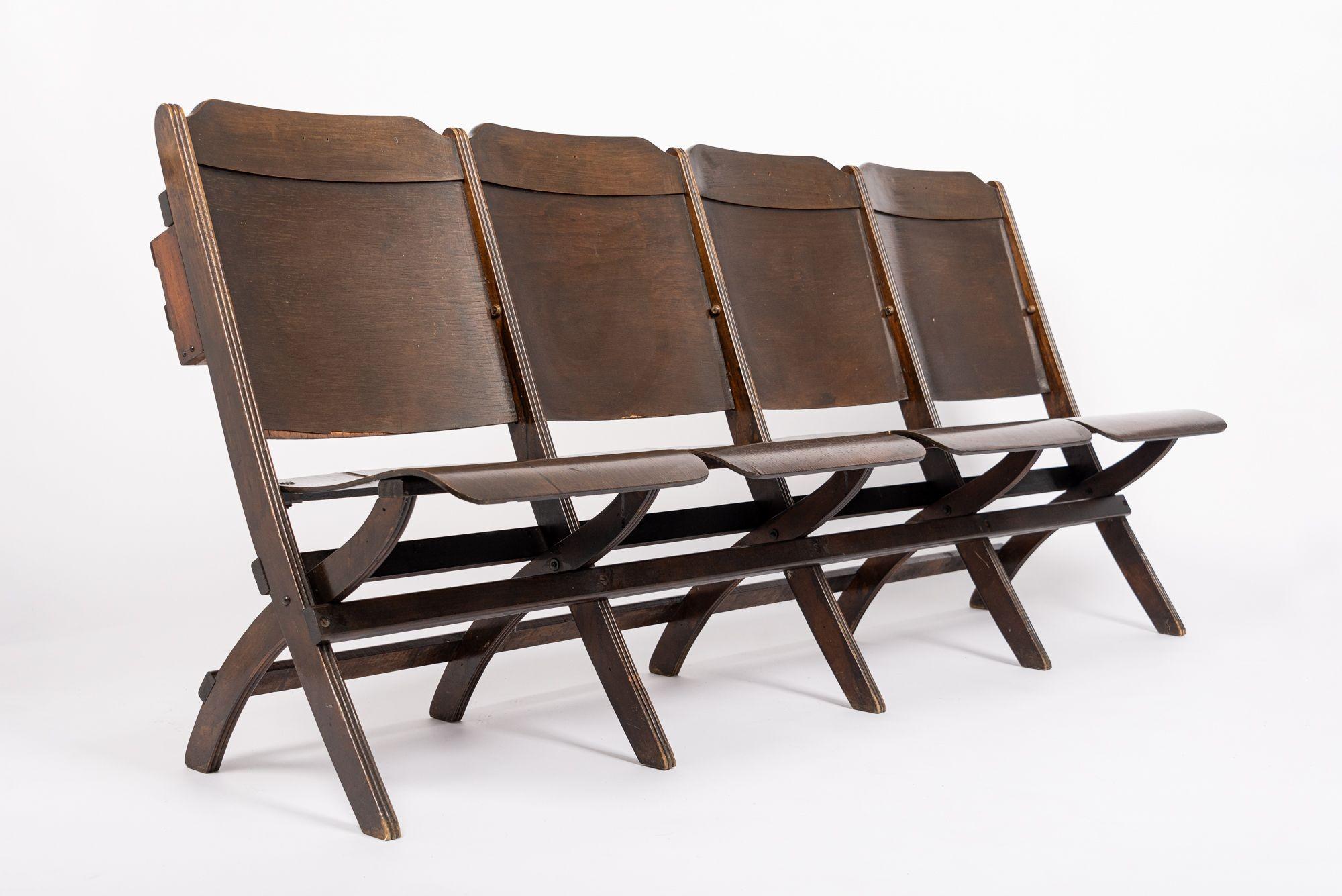 These classic wooden antique folding theater seats are from the General Motors building auditorium in Detroit, MI. This attached four seat set features liftable seats and two wooden book holders on backside. The set also folds up completely for