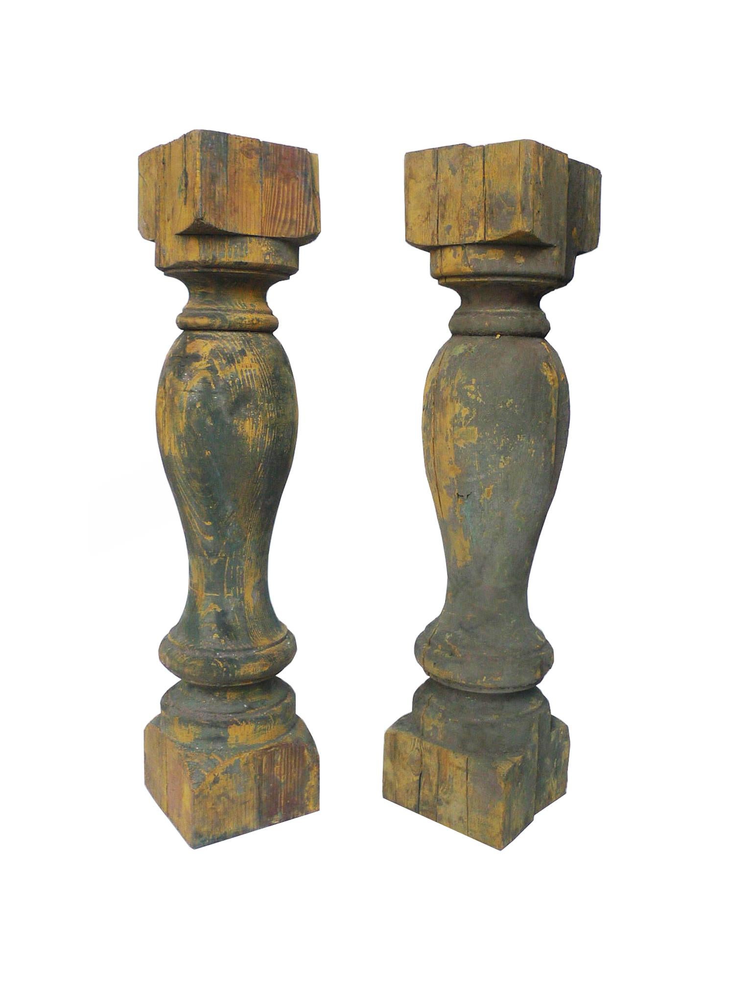 These yellow-painted wood balusters are antique and were handcrafted. They've accrued a beautiful patina of grayish green atop the yellow. As decorative objects, each pair has versatile use. They can be: converted into lamps; used as table legs or