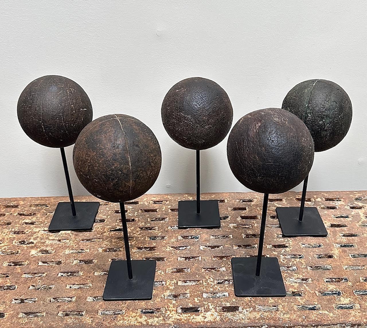 Une Collectional de 5 boules de Bocce en bois antiques, toutes montées sur des supports en acier faits sur mesure. Bois dense et lourd. De belles surfaces intactes. L'aspect est très organique et primitif. Les boules elles-mêmes mesurent 4