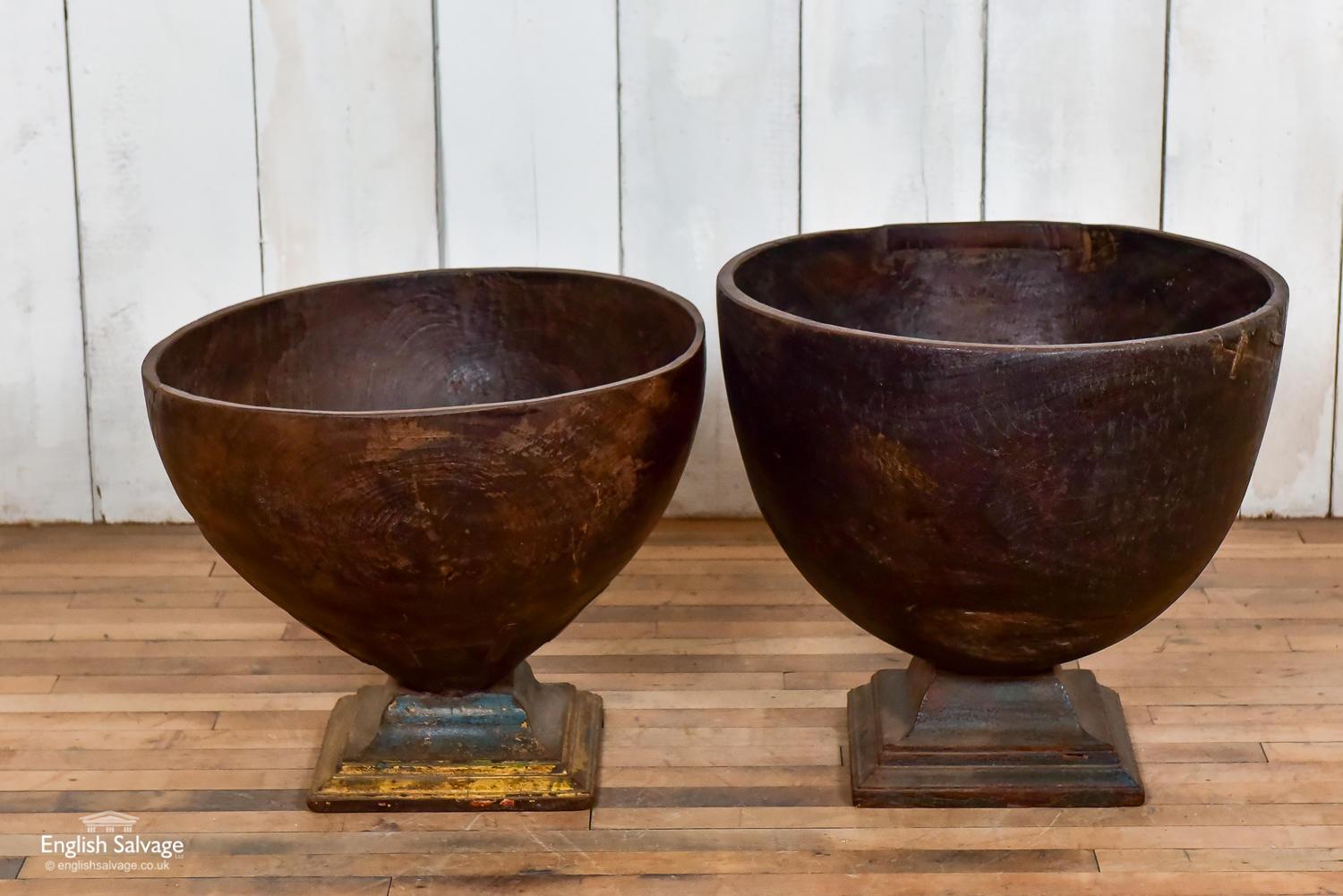 Impressive old teak bowls with strap iron reinforcements. The bowls are carved from single pieces of wood which are then mounted onto wooden stands.
