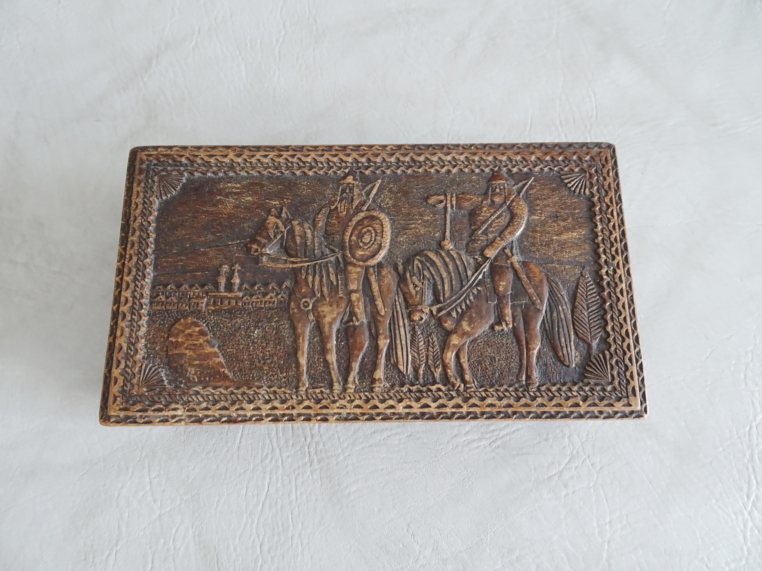 Arts & Crafts antique wooden box from historicism from 1900 to 1910. The wooden box shows a scene of two riders with shield and sword and a carrier pigeon in front and floral ornaments on the side. In the wooden lid a slightly disreputable and