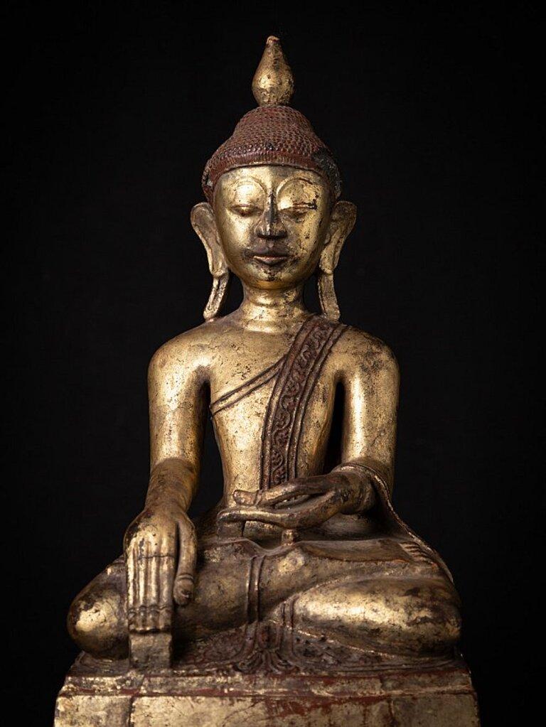 Material: wood
57 cm high 
26,3 cm wide and 18 cm deep
Weight: 4.967 kgs
Gilded with 24 krt. gold
Shan (Tai Yai) style
Bhumisparsha mudra
Originating from Burma
18th century
With Burmese inscriptions in the base.
 