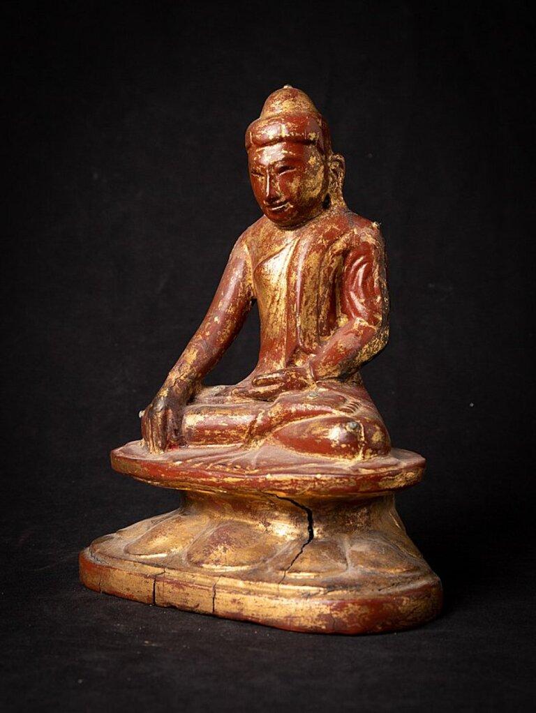 Material: wood
27 cm high 
21,5 cm wide and 14,6 cm deep
Weight: 1.270 kgs
Gilded with 24 krt. gold
Shan (Tai Yai) style
Bhumisparsha mudra
Originating from Burma
Early 19th century
With hollow space, in the back of the pedestal. Probably