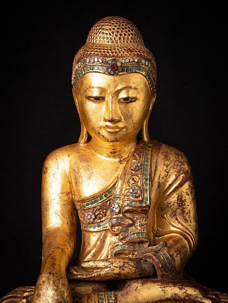 MATERIAL: Holz
43 cm hoch 
35,3 cm breit und 24,3 cm tief
Gewicht: 6,013 kg
Vergoldet mit 24 krt. Gold
Mandalay-Stil
Bhumisparsha Mudra
Mit Ursprung in Birma
19. Jahrhundert
Mit eingefügten Augen
