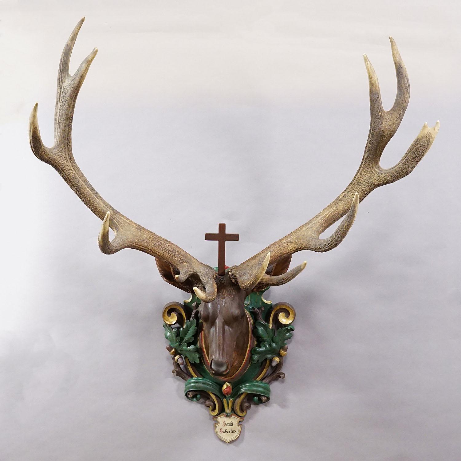 Antiquités en bois sculpté Black Forest Tête de cerf Hubertus avec trophée 14 pointes

Grande tête de cerf antique Hubertus de la Forêt Noire avec un trophée de cerf à 14 extrémités inégales. Sculptée dans le style baroque vers 1900, elle est montée