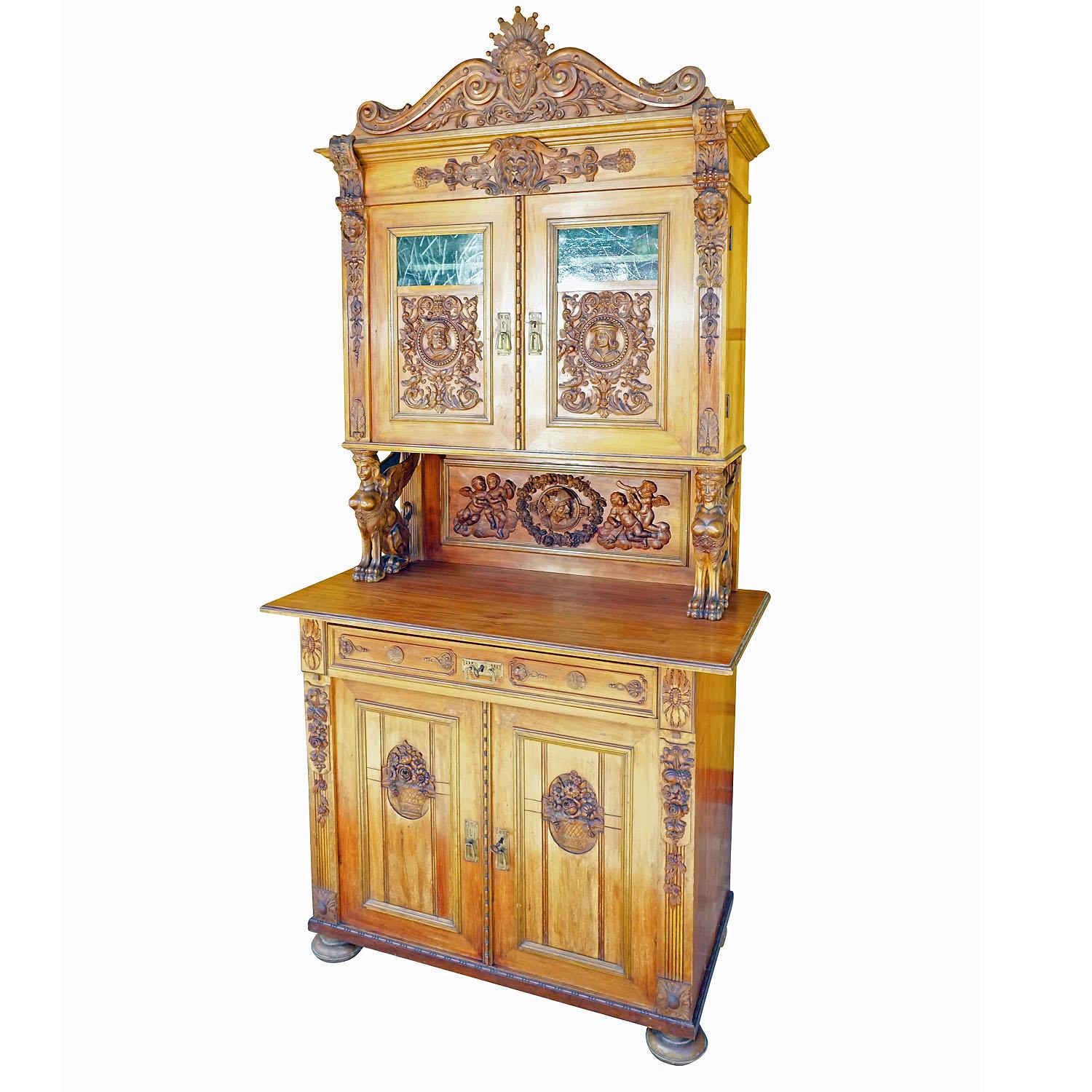 Antique Wooden Carved Cupboard with Several Carvings

A detailed handcarved wooden buffet or cupboard with several elaborately carved wooden decorations depicting lion, putties, angels, eagles and gargoiles. Manufactured in Germany ca. 1920.