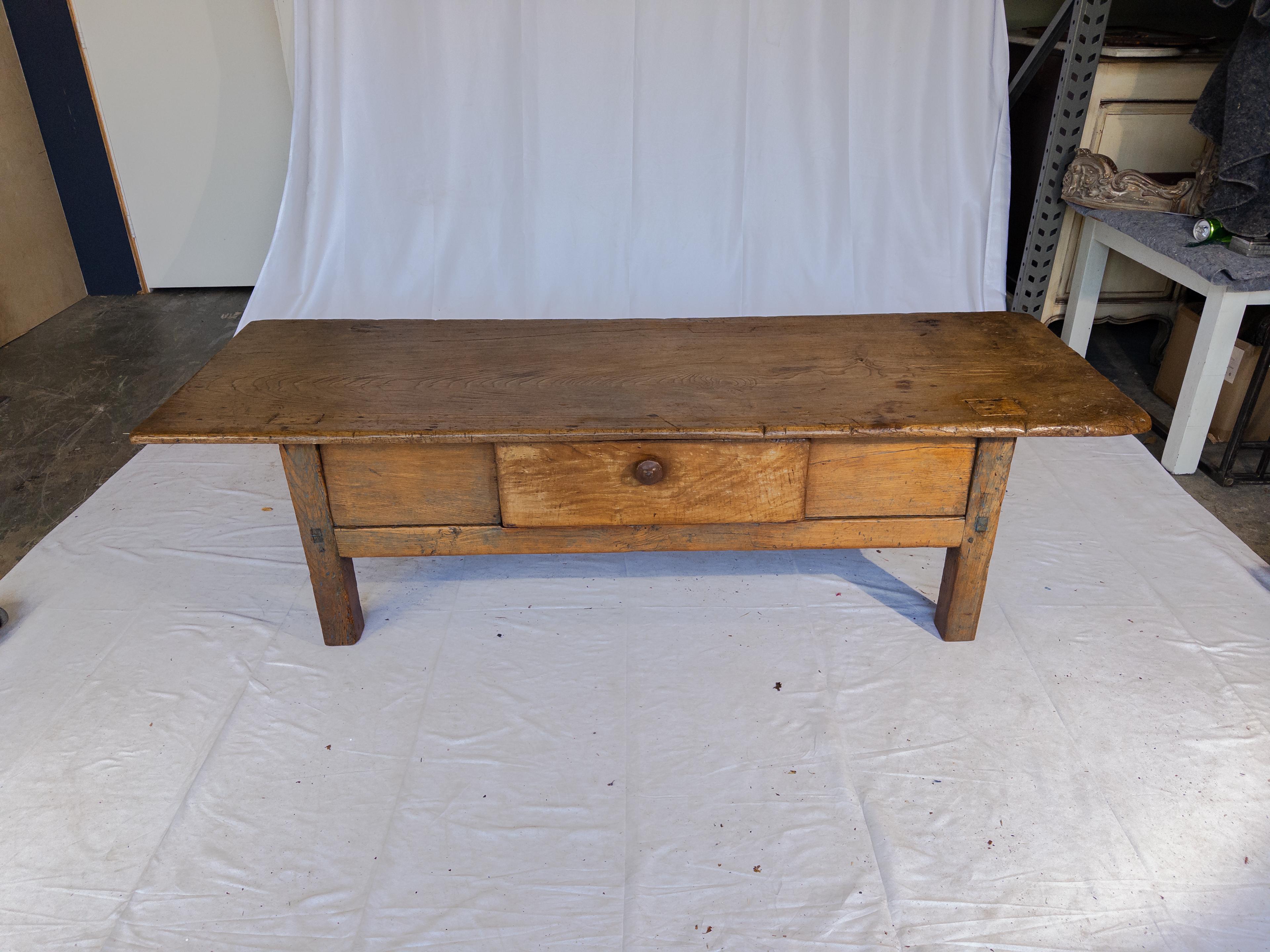 La table basse ancienne en bois témoigne de l'attrait durable de l'artisanat vintage. Fabriquée en bois riche et vieilli, sa surface porte la patine des années passées, chaque imperfection racontant sa propre histoire. L'ajout d'un tiroir unique