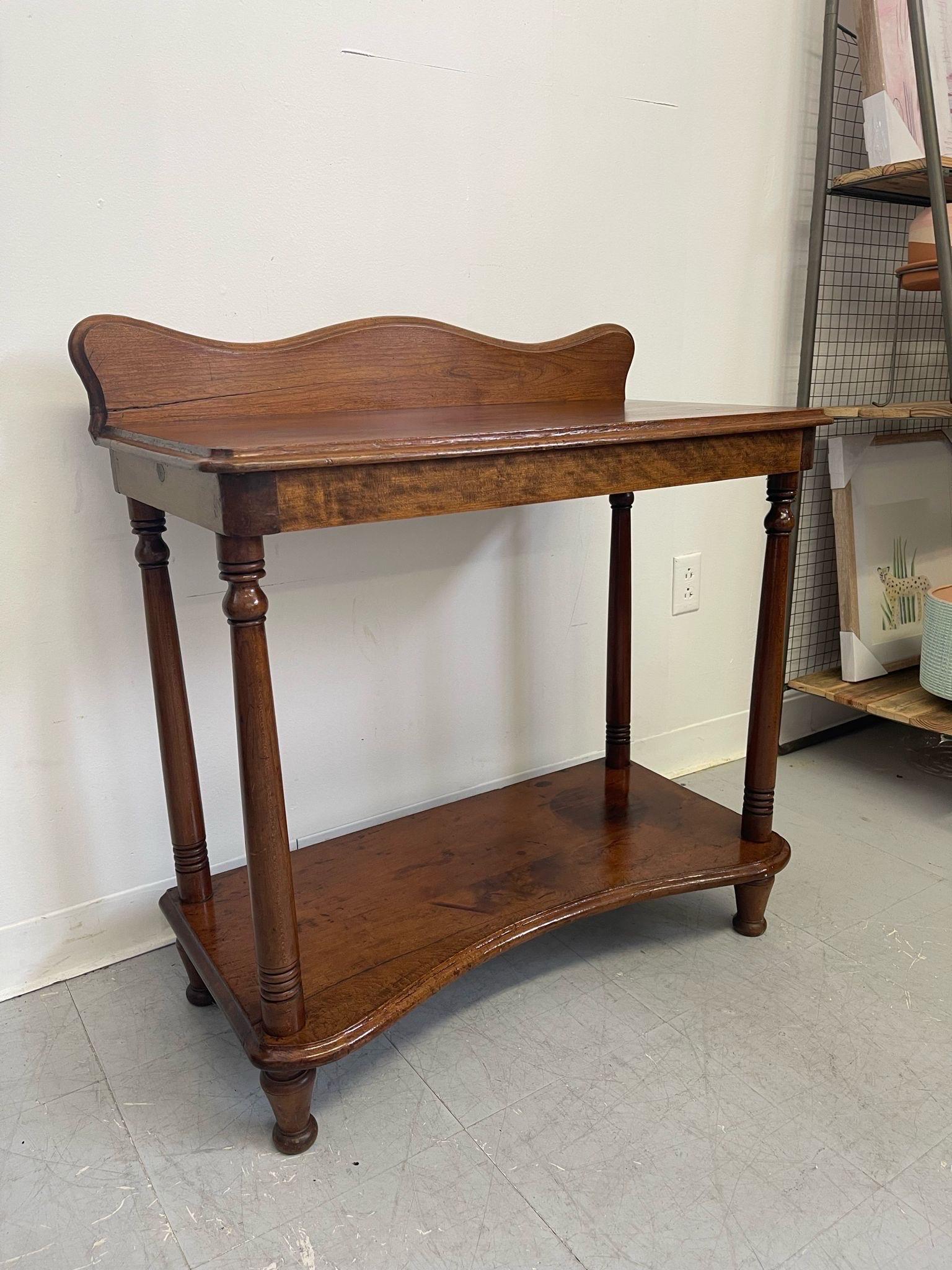 This Table has Curved wood back and curved front to the lower shelf. Attached receipt from 1977 states that the Table is made from Cherry wood circa1850s. Although we are unable to confirm. Vintage Condition Consistent with Age as