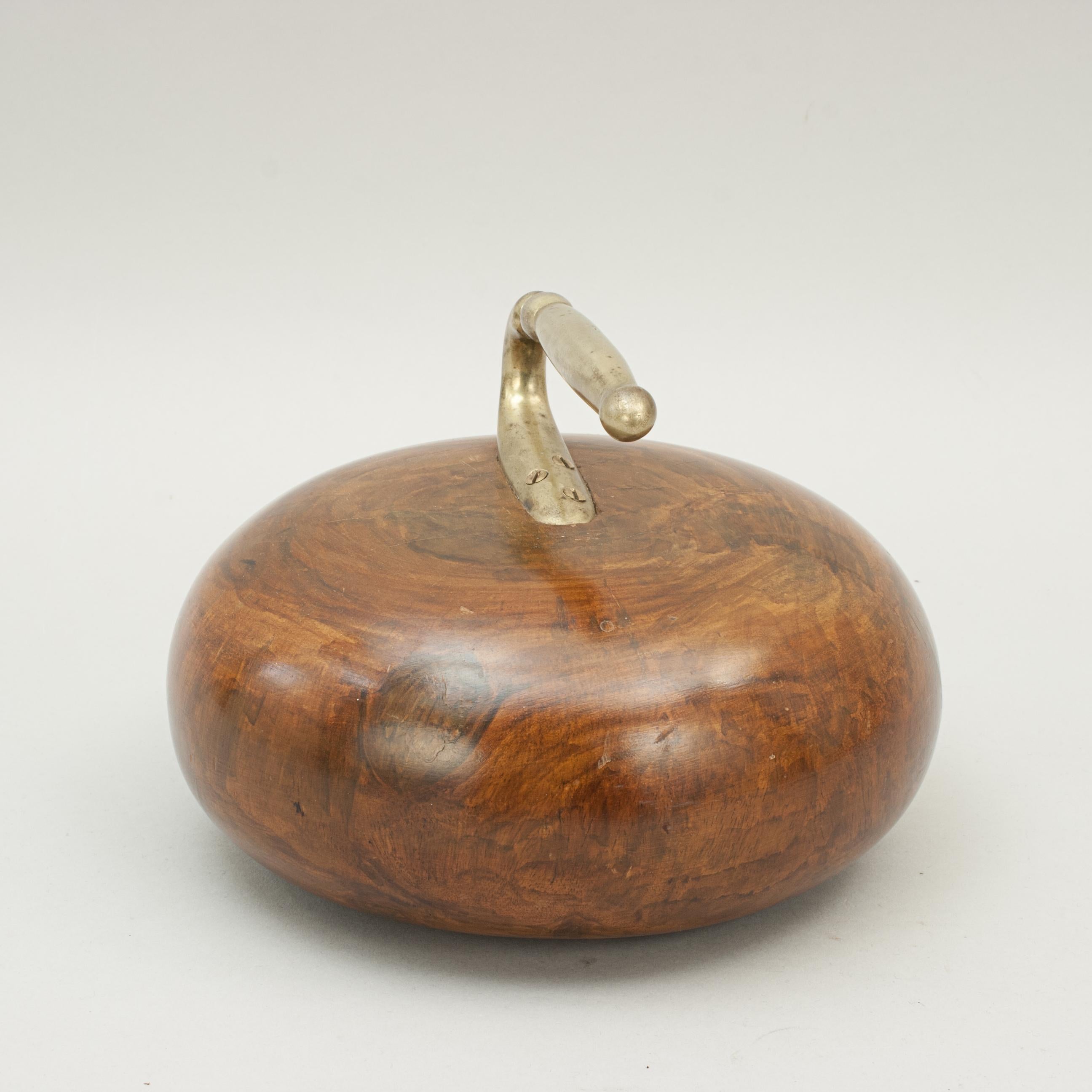 Wooden curling stone.
A nicely turned wooden curling stone with inset brass handle. The wooden curling 'stone' makes a great door stop. The finish has some painted on wood effect on top of the natural wood grain.