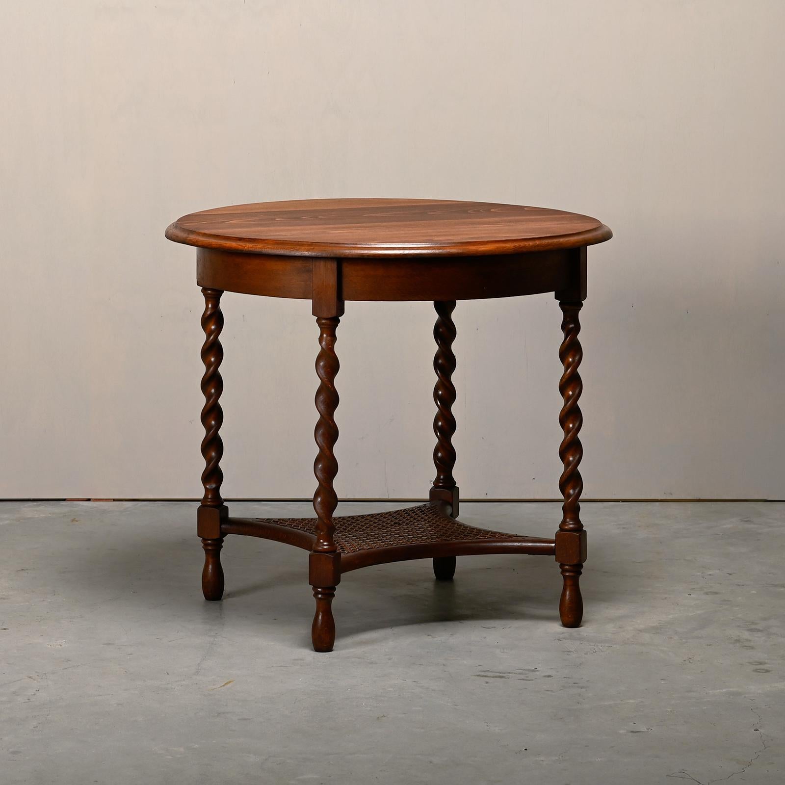 Elegant antique English side table from the late 19th century. Solid wood table top with relief edge on turned bobbin legs. The legs are connected with a small plank covered in straw. Beautiful and good vintage condition.