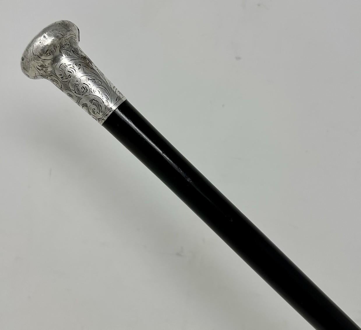 Fine Quality French Polished Heavy Gauge Ebony Walking Cane Stick with Highly Decorative Embossed Silver Grip, made by renowned English Stick Maker Jonathan Howell.  
The circular silver knopped grip above a tapering turned Ebony shaft complete with