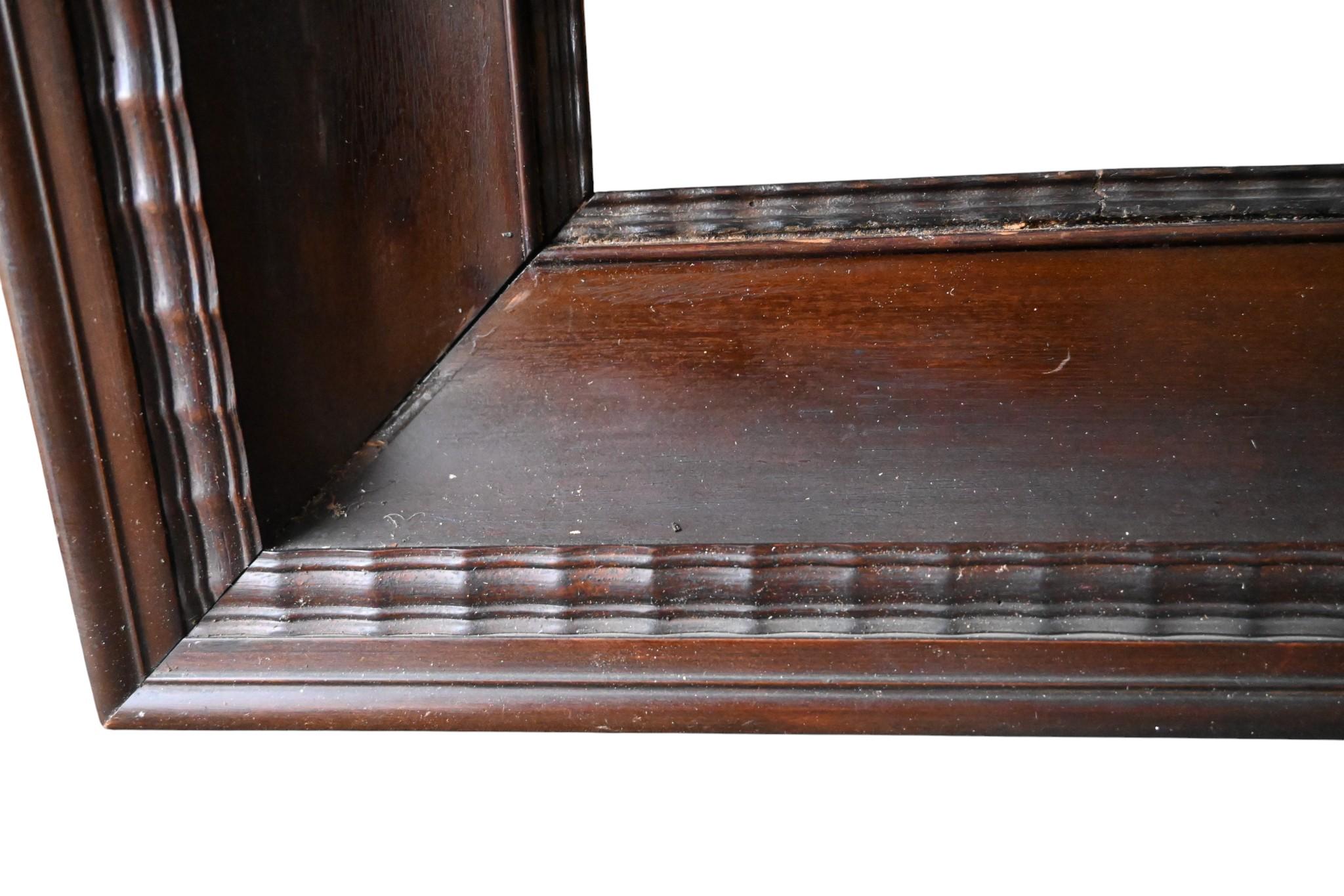 Elegant antique wooden picture frame, dating from the 19th century (possibly late 18th). Crafted in solid wood with a rich dark brown patina and a finely carved ribbed moulding along the inner and outer edges. The frame shows authentic age-related